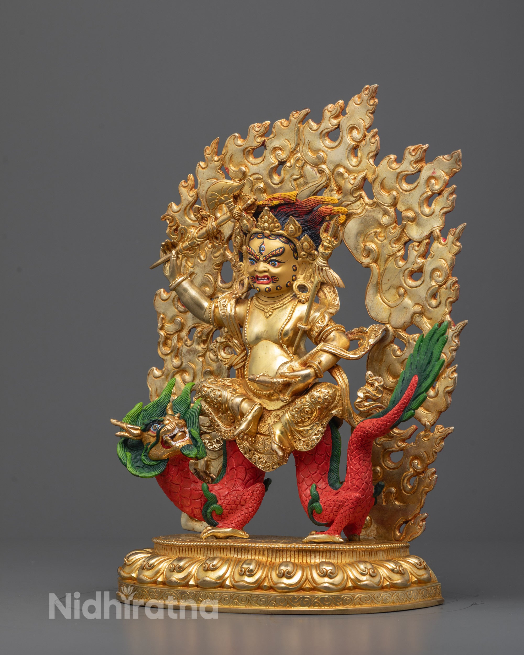 Side view of White Dzambhala statue highlighting detailed gold gilding