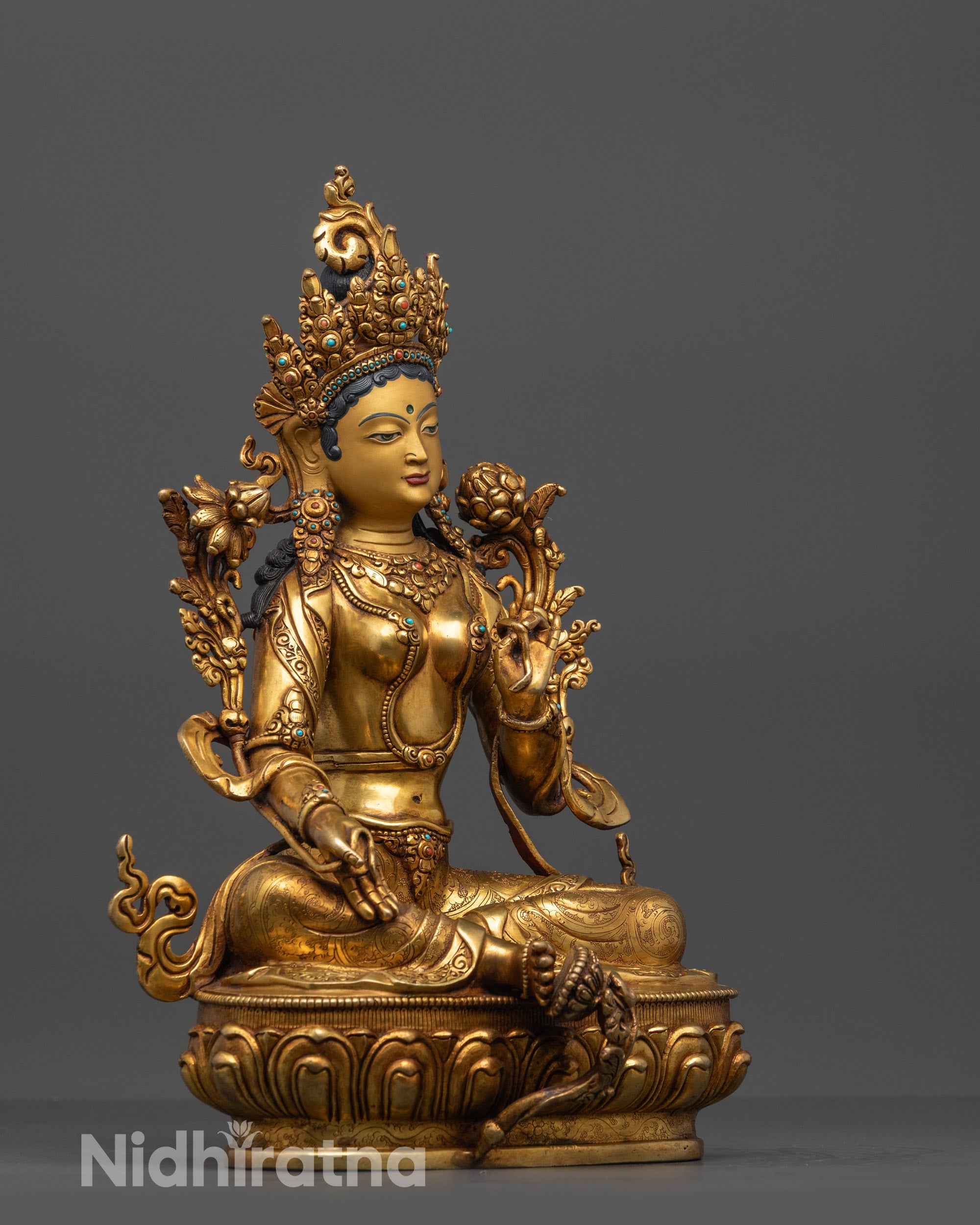 Side view of handcrafted Green Tara sculpture seated on lotus throne
