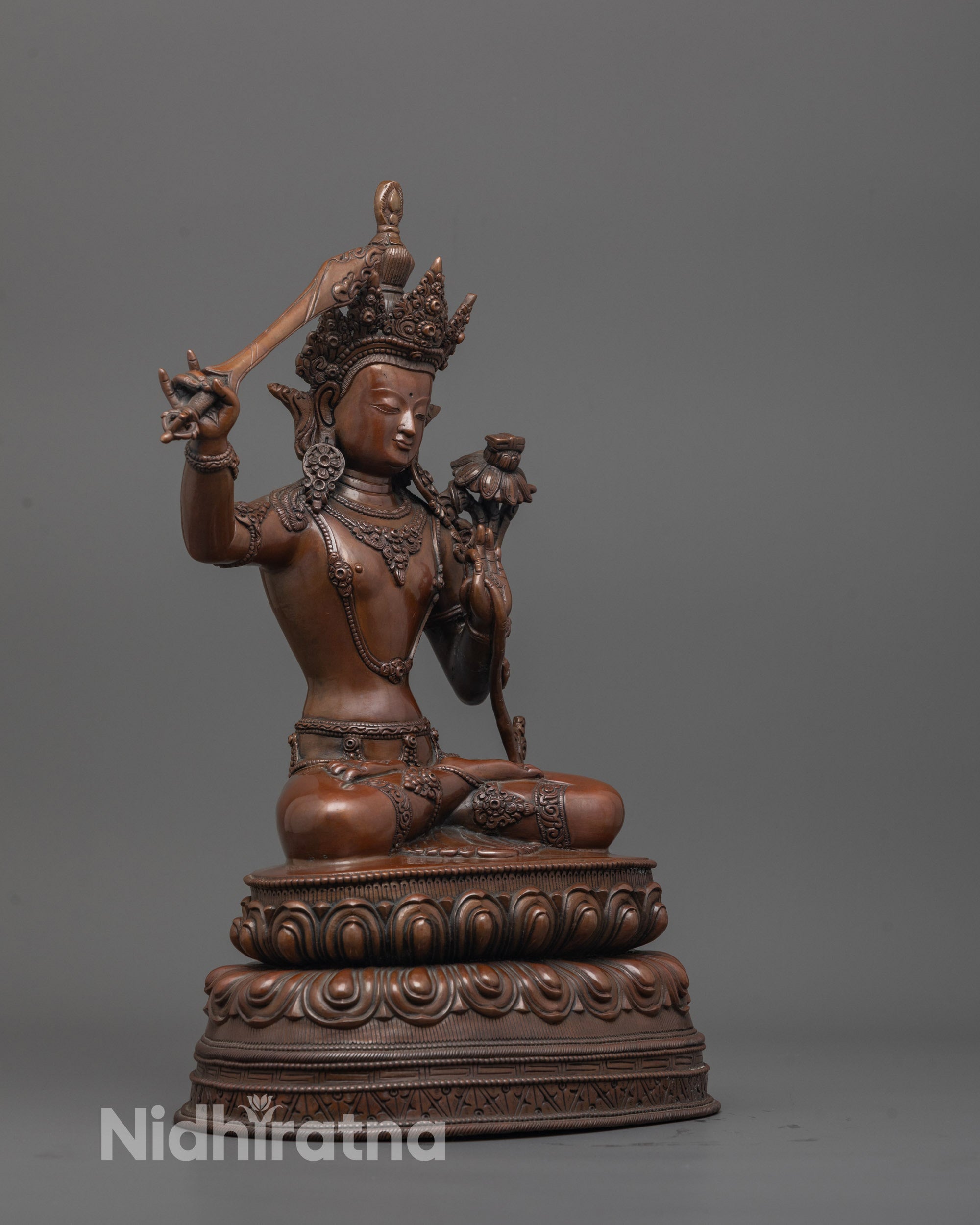 Side view of handcrafted Manjushri Statue seated in meditation on double lotus base