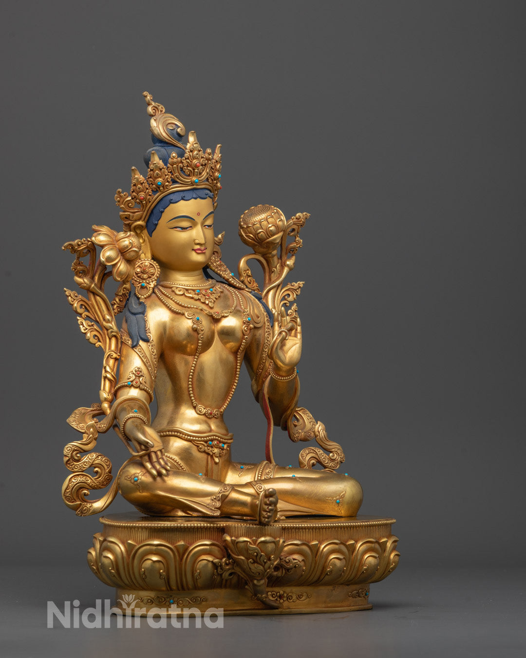 Side view of the Green Tara statue highlighting the radiant gold finish