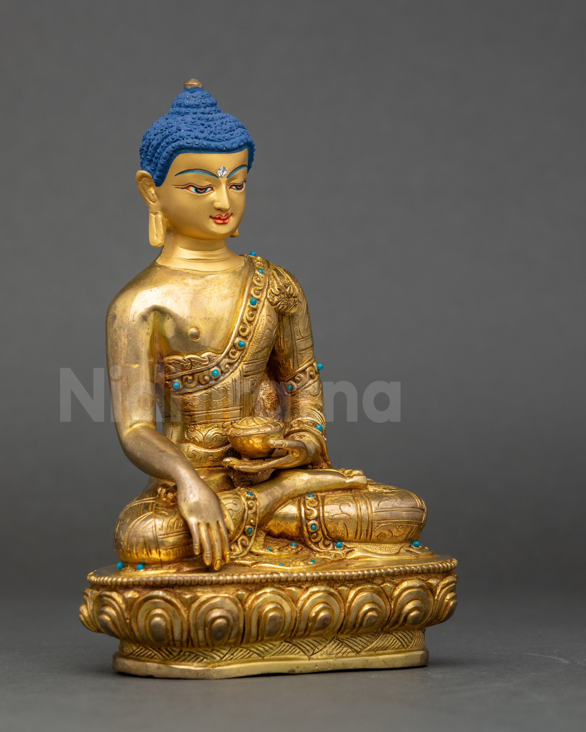 Side view of traditional lost wax Nepalese Buddha statue with intricate robe carvings