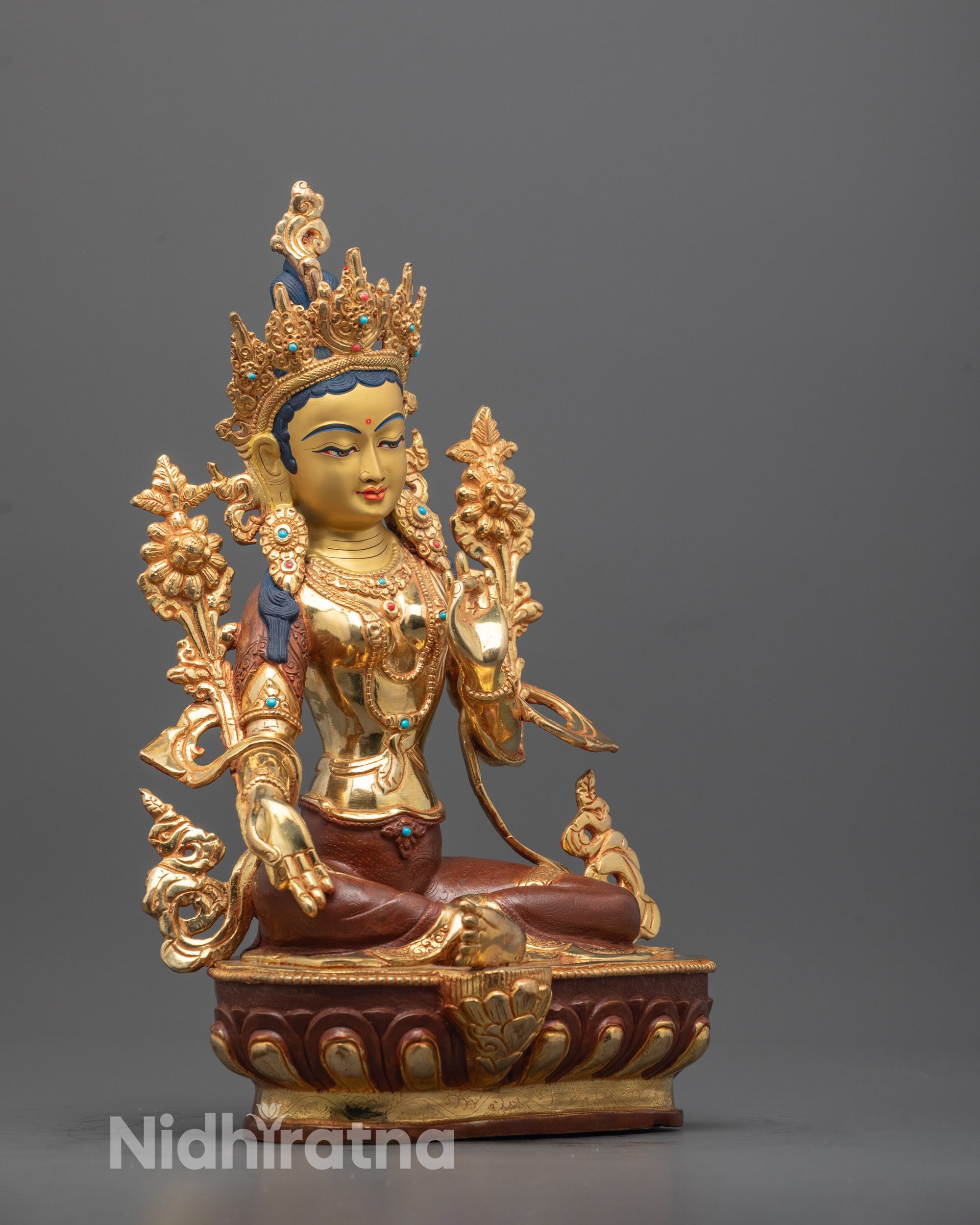Side view showing finely carved robes and gold accents on Green Tara Statue
