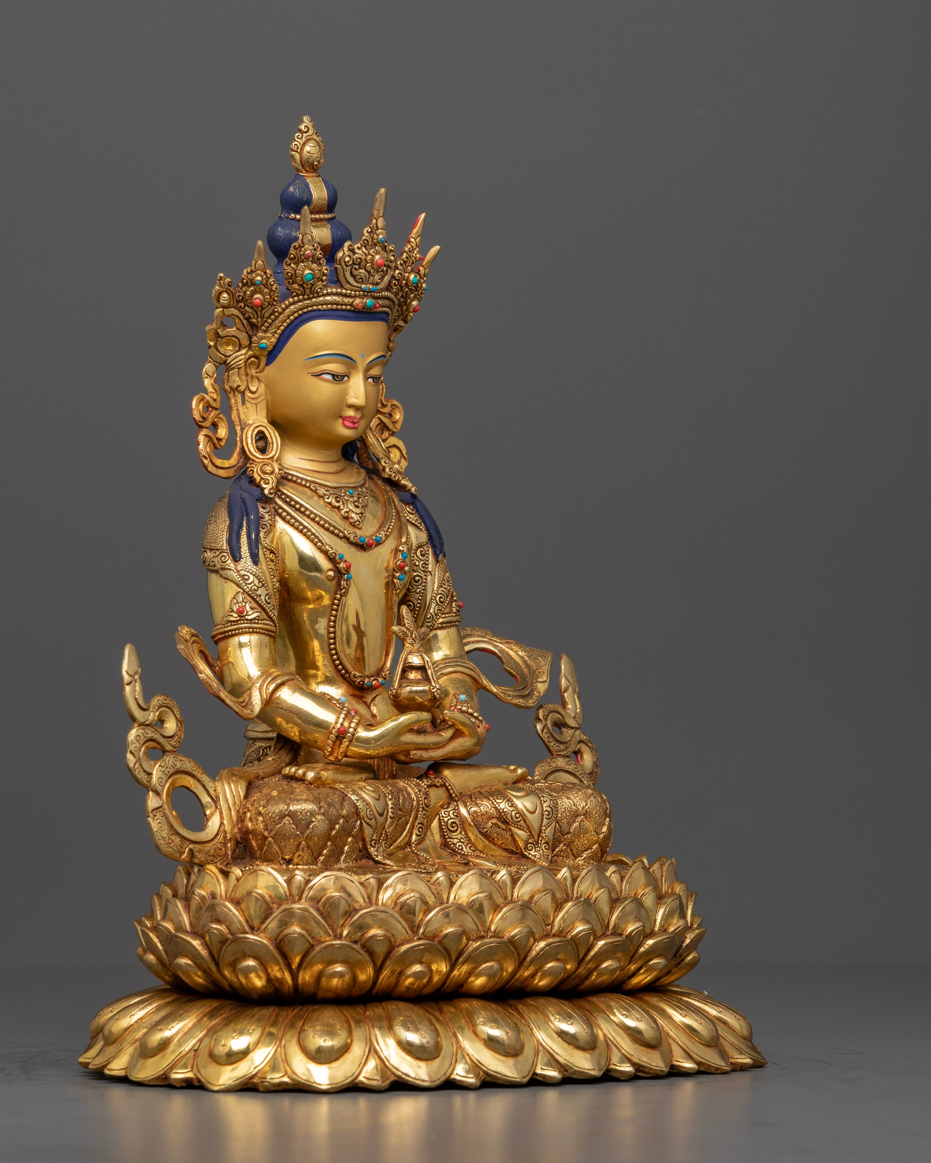 The Amitayus statue, showcasing the flowing robes, delicate lotus seat carvings, and the symbolic nectar vessel, emphasizing the statue's craftsmanship and sacred significance.