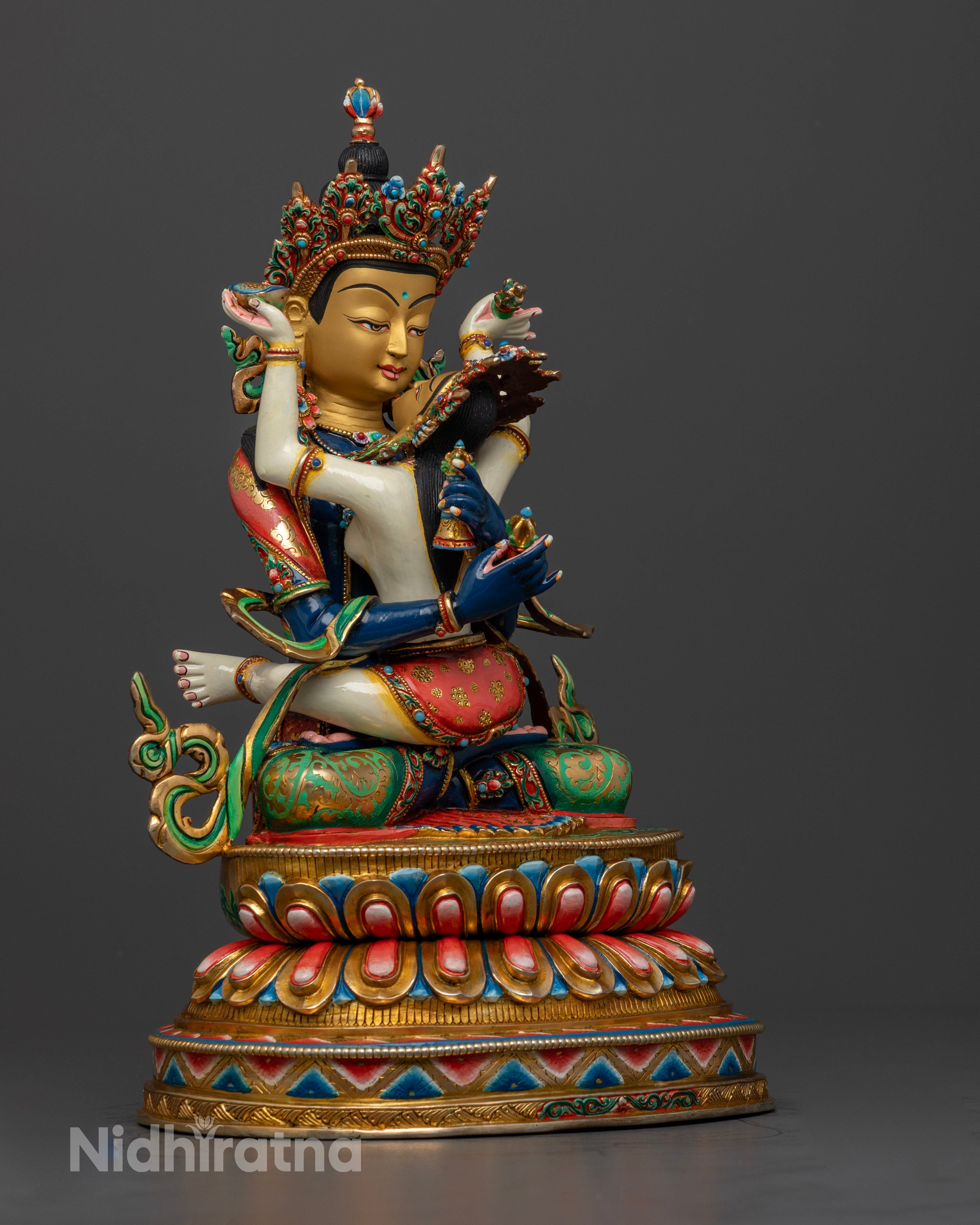 The Vajradhara statue, showcasing the elaborate hand-carved designs, flowing robes, and the brilliance of embedded semi-precious stones.