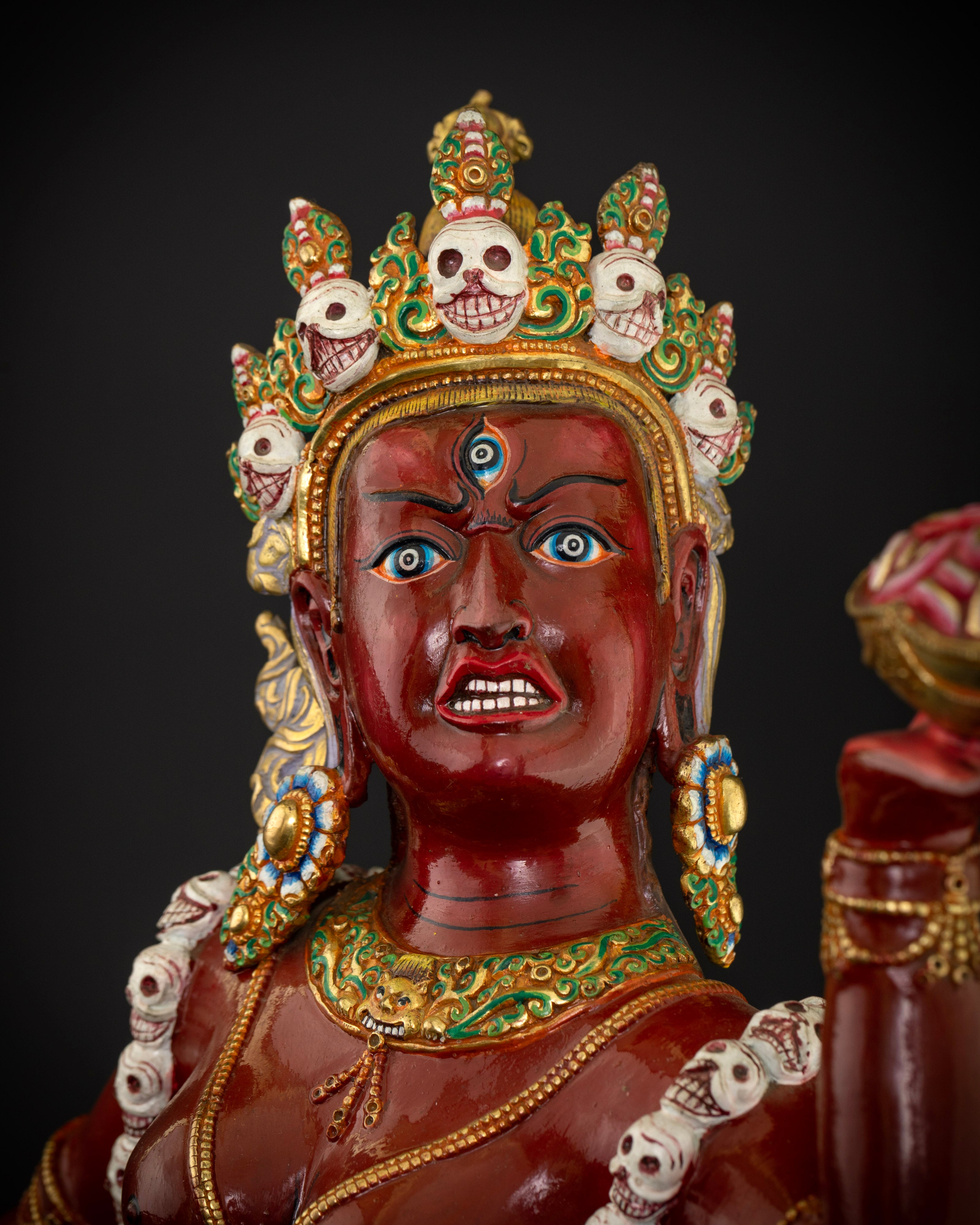 The Vajrayogini statue’s fiery and powerful face, showcasing intricate detailing, vibrant acrylic paint, and symbolic spiritual elements like the third eye.