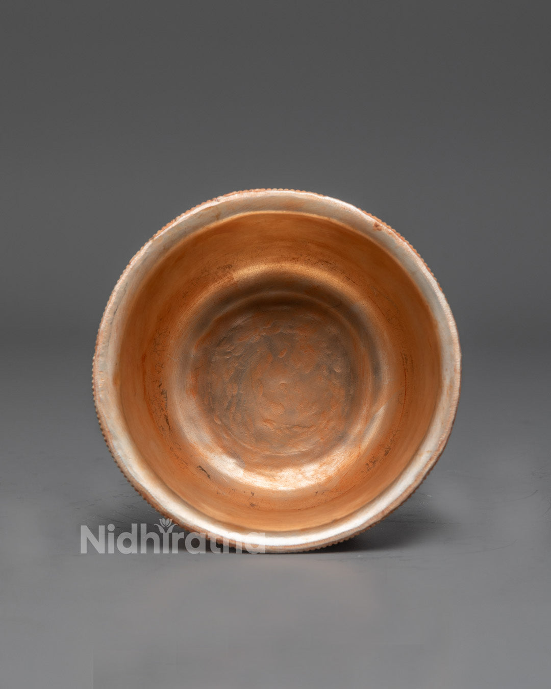 Top view of traditional copper Watering Offering Bowl with silver finish and interactive designs