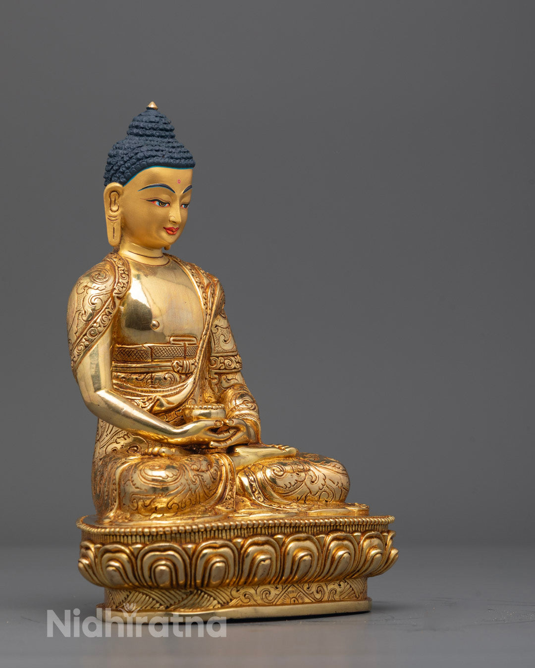 Traditional Nepalese Amitabha Buddha statue with glowing gold face and detailed lotus base