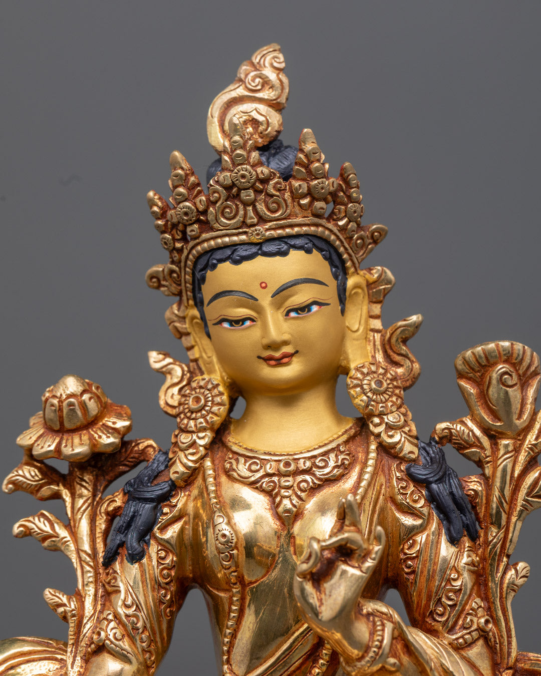 Traditional Nepalese Green Tara sculpture featuring a serene youthful figure in green, adorned with semi-precious stones and gold gilding.