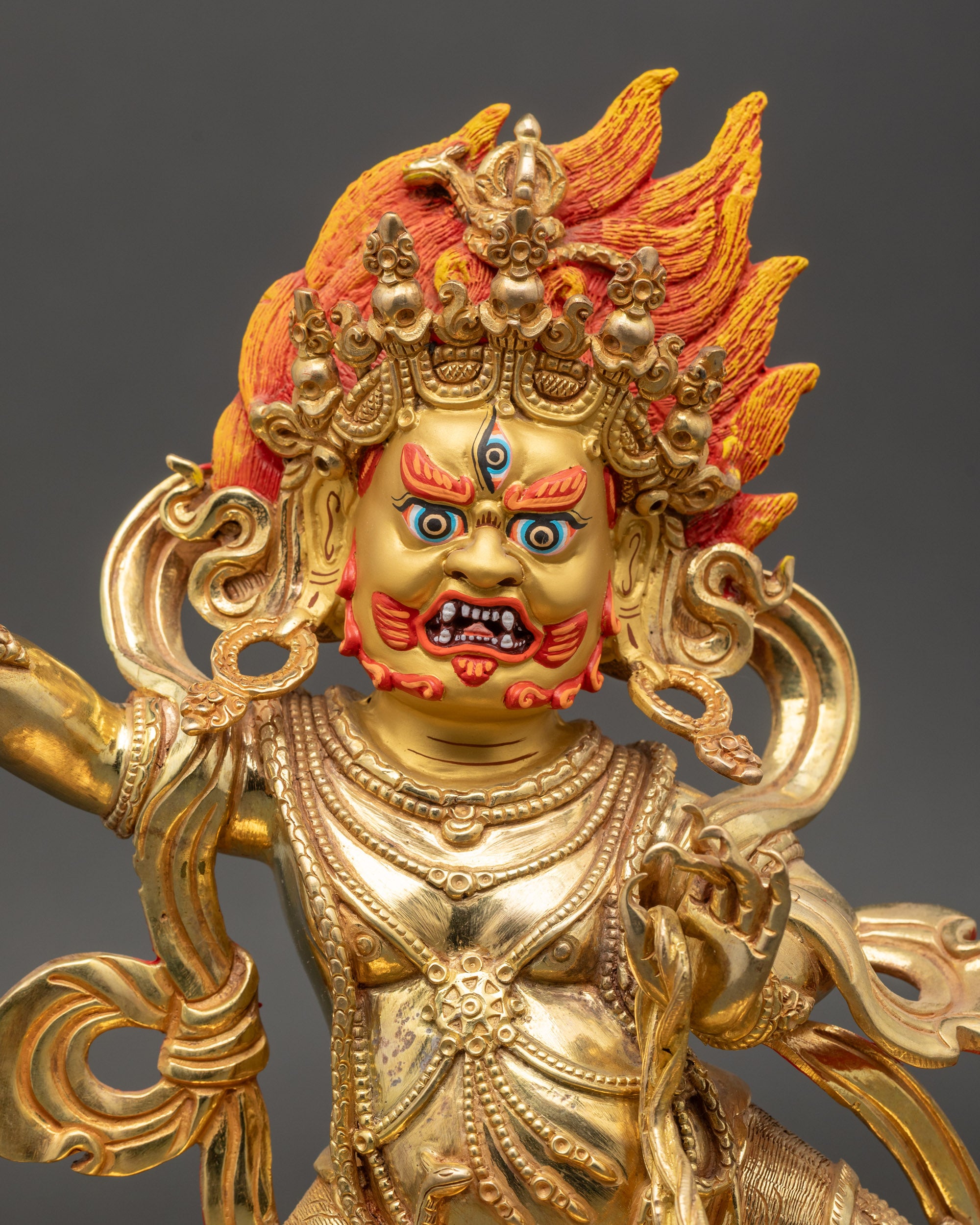 Vajrapani wrathful face with third eye and intricate gold-painted detailing