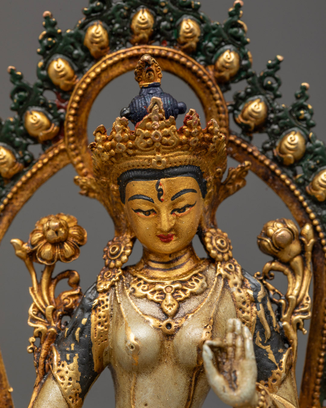 Intricately carved White Tara statue adorned with lotus flowers and seven all-seeing eyes symbolizing compassion, longevity, and protection
