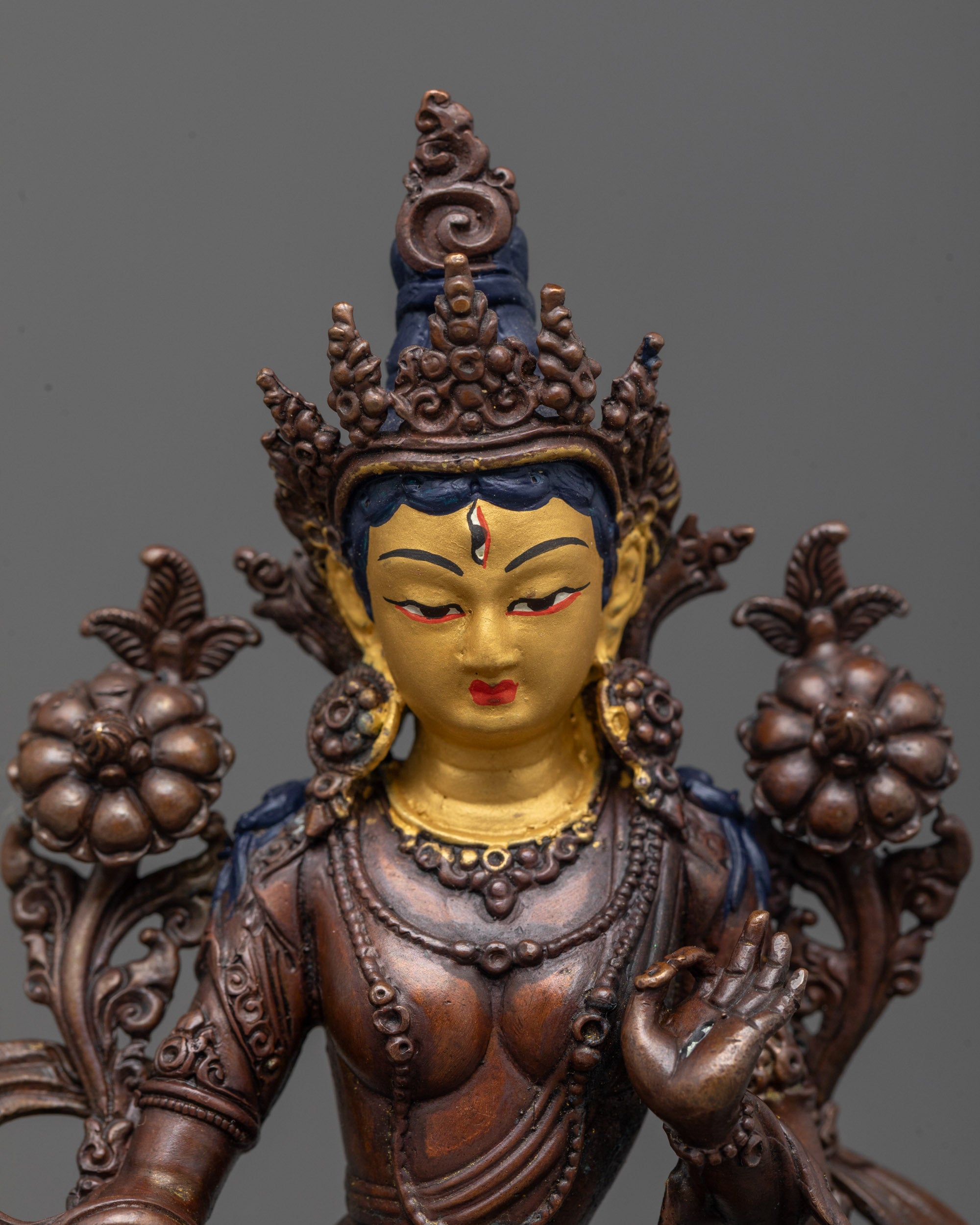 close up White Tara Statue gold-plated face and utpala flower in Abhaya mudra