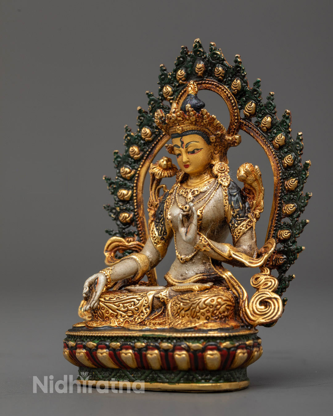 Detailed carving on White Tara statue’s crown, jewelry, robes, and uptala flowers with rich acrylic paint