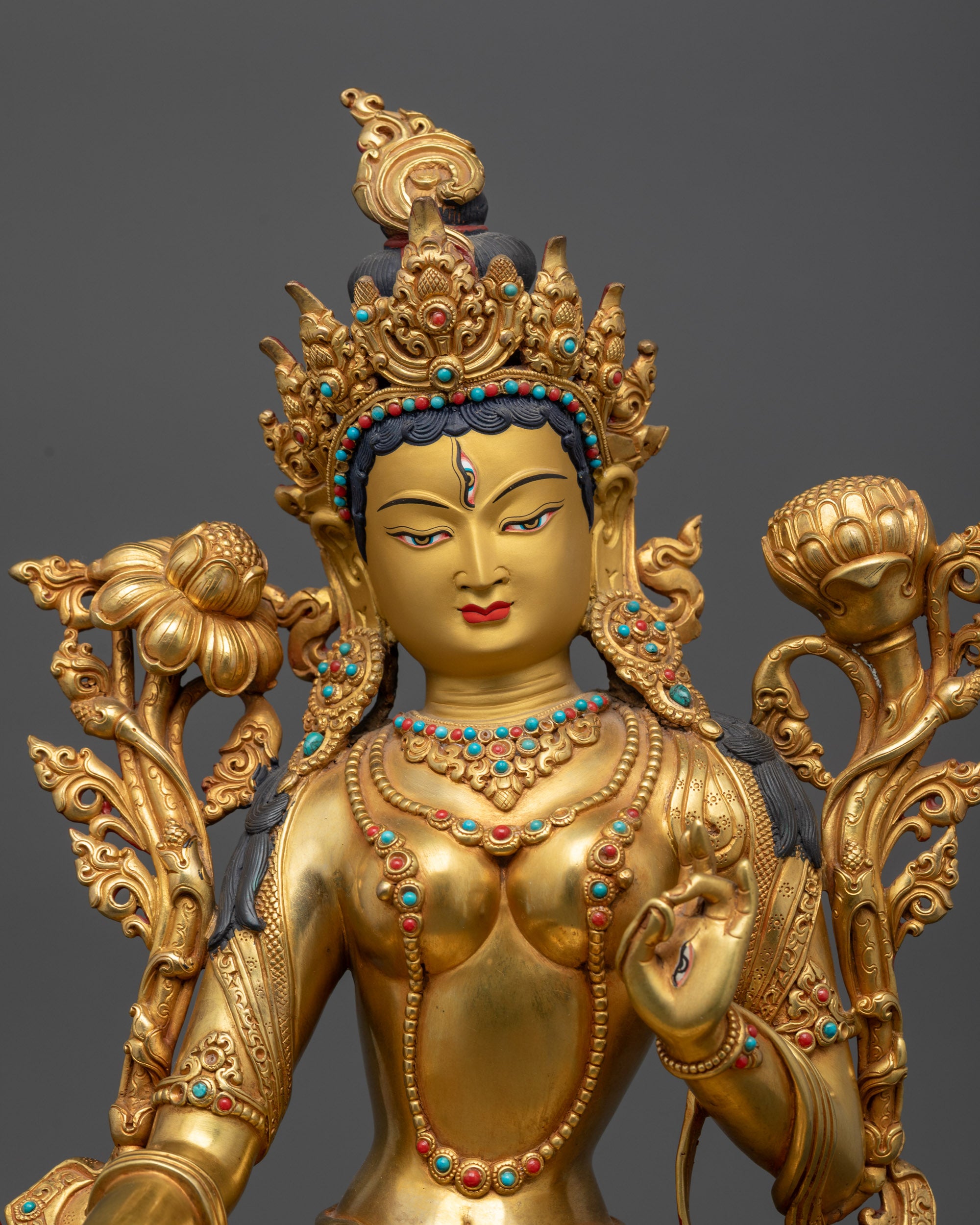 White Tara statue close up showing flowing robe and semi-precious stones