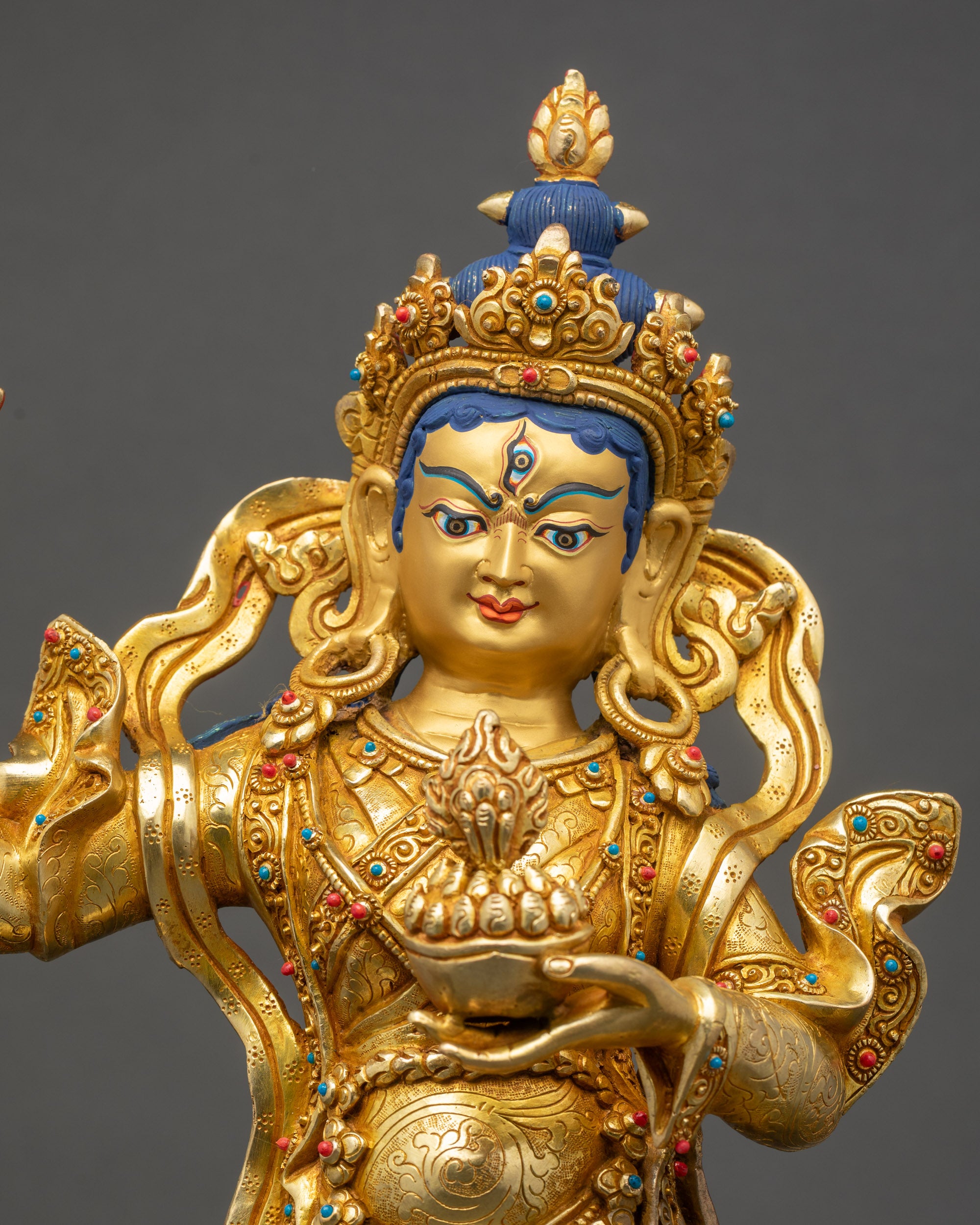 Close up of Achi Chokyi Drolma Buddhist statue with gold fire gilding and intricate details