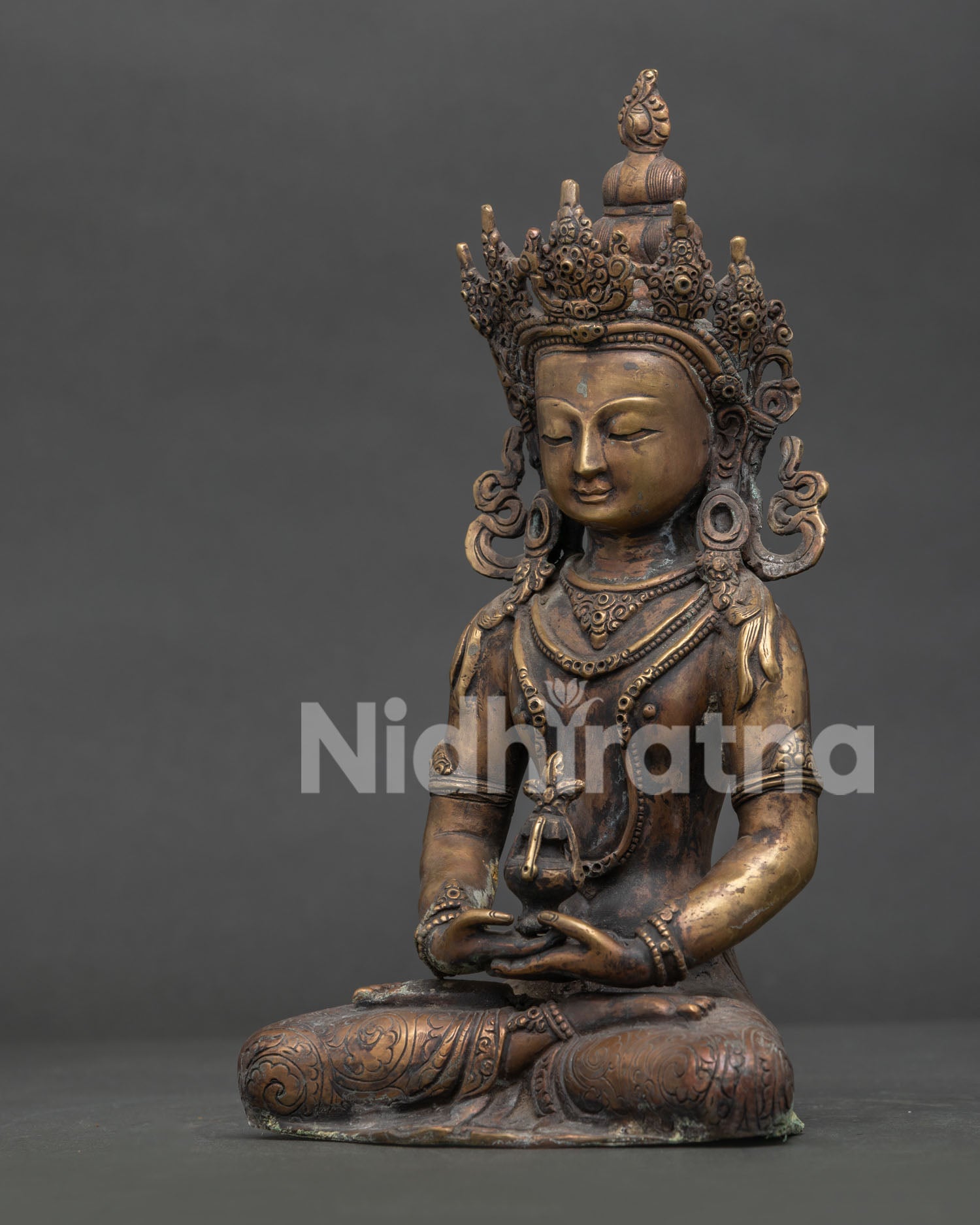 Amitayus statue side view showing hand carved silk garment layered necklaces and sacred vase.