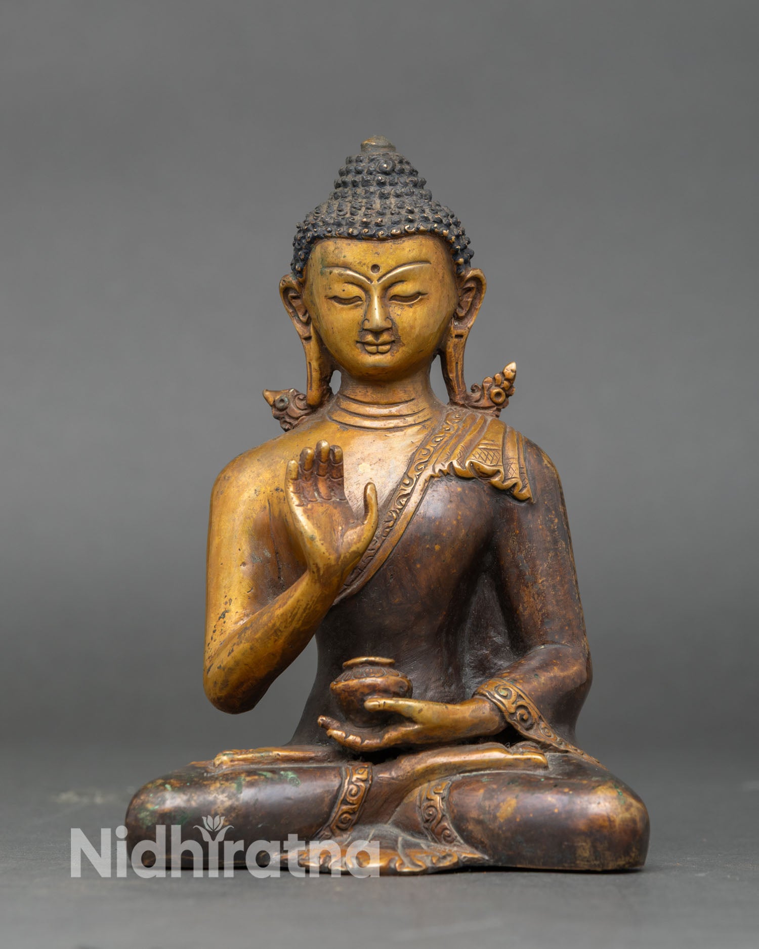 Amoghasiddhi Buddha statue Abhaya mudra raised hand symbol of fearlessness protection and spiritual strength oxidized copper Vajrayana Buddhist art