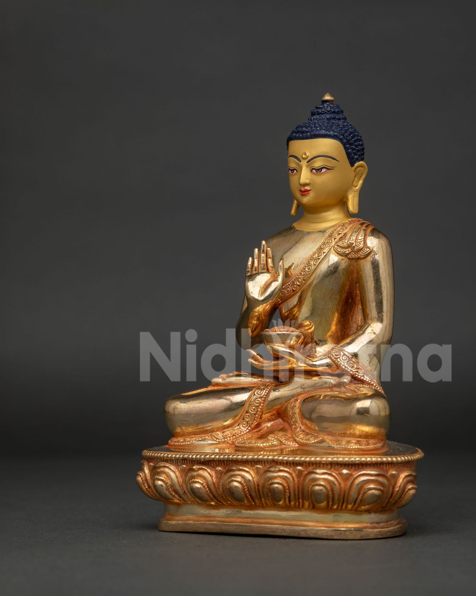 Amoghasiddhi Buddha statue side view with lotus pedestal and carved floral robe.