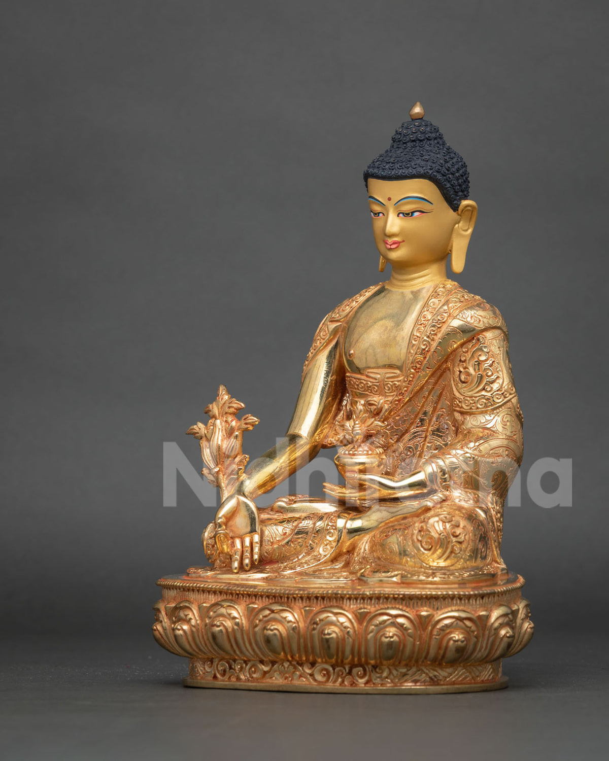 Angled side view of fire-gilded Medicine Buddha holding myrobalan stem and nectar bowl