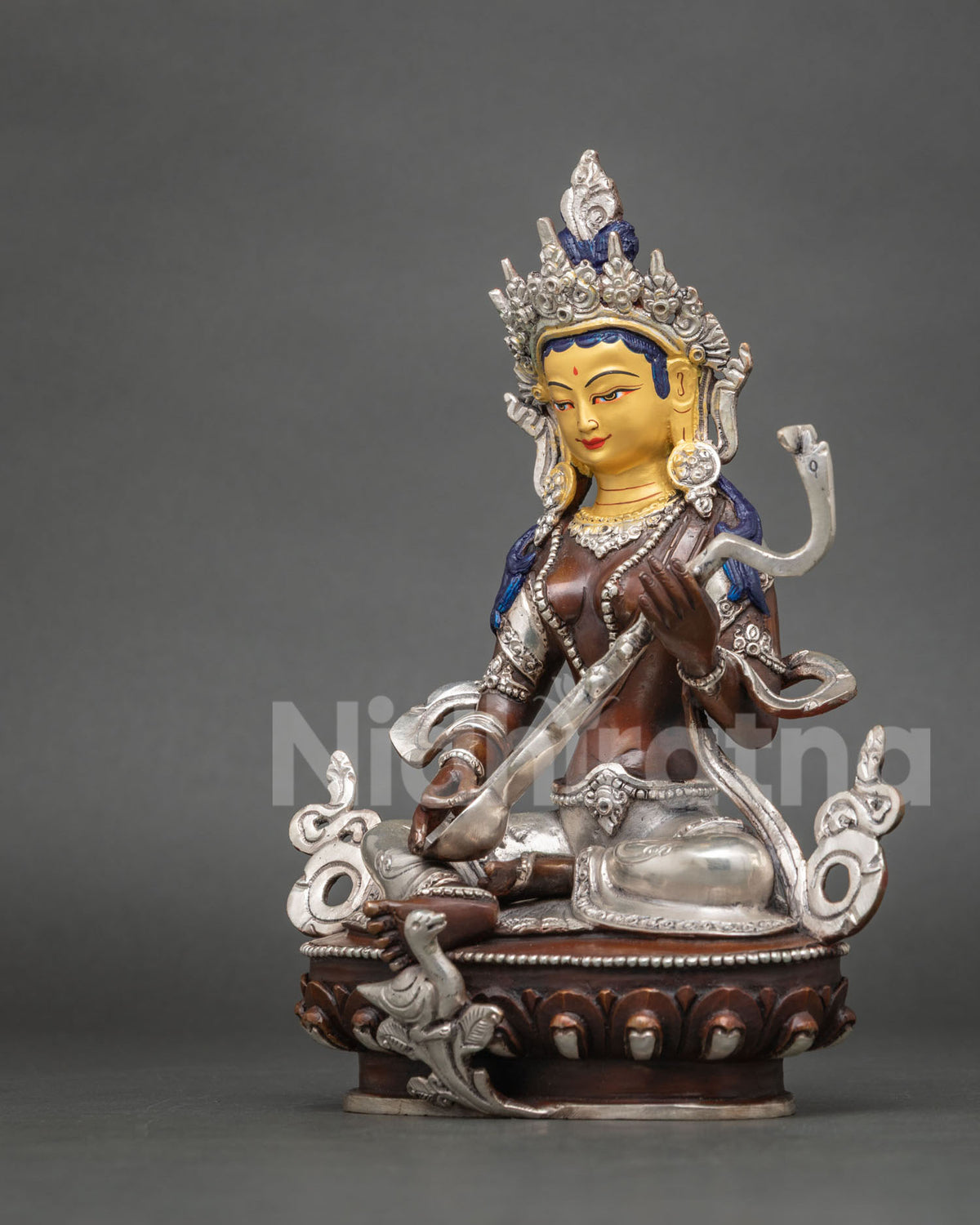 Angled side view of handcrafted Saraswati statue showing veena and silver-plated swan detail