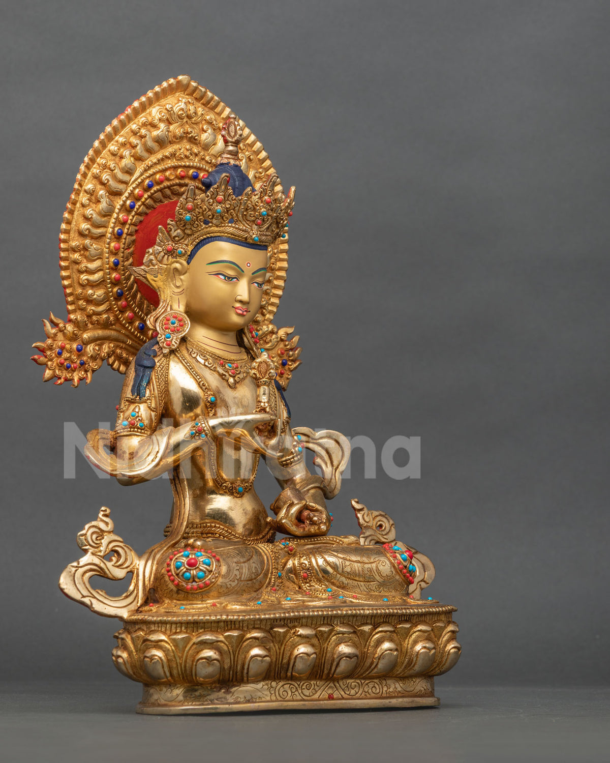 Angled side view of handmade Vajrasattva Buddha statue with turquoise and coral inlay on lotus throne