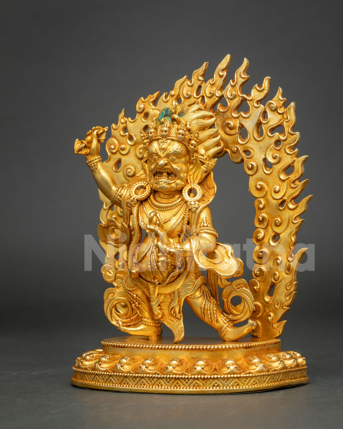 Angled view of gold Vajrapani Bodhisattva figurine in dynamic wrathful stance on lotus base