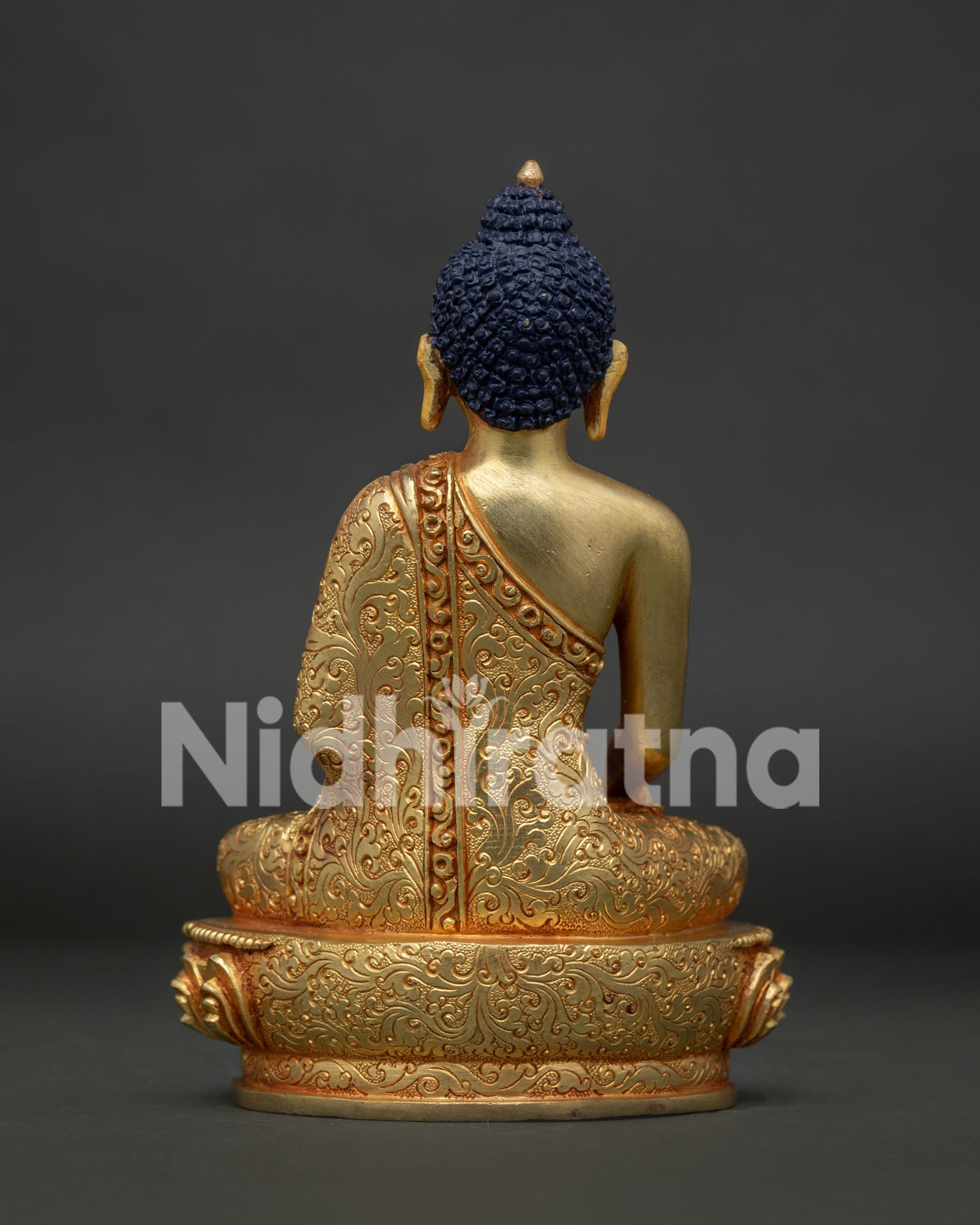 Back of statue showing engraved deer and Dharma Chakra on lotus base.