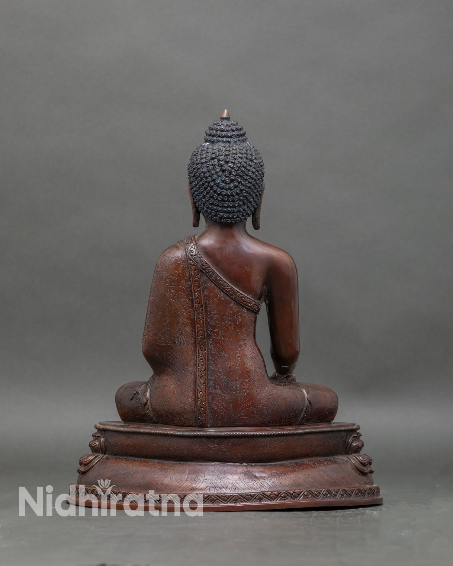 Back view of Buddha Shakyamuni statue seated on lotus pedestal for meditation and altar decor