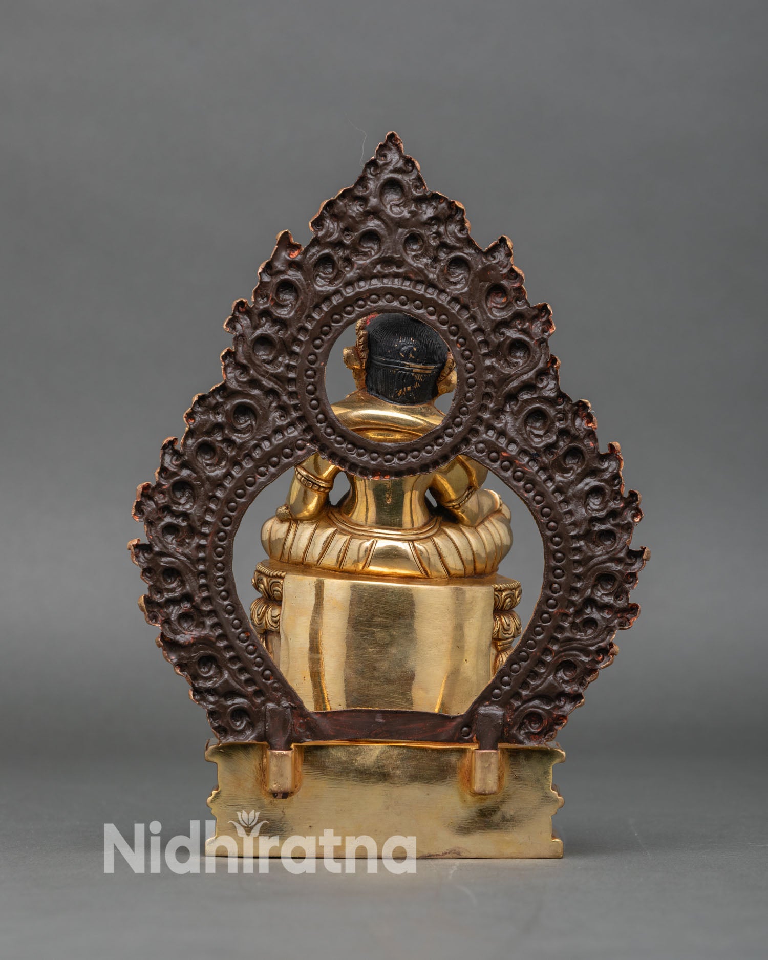 Back view dzambhala statue celestial pedestal and ornate floral halo