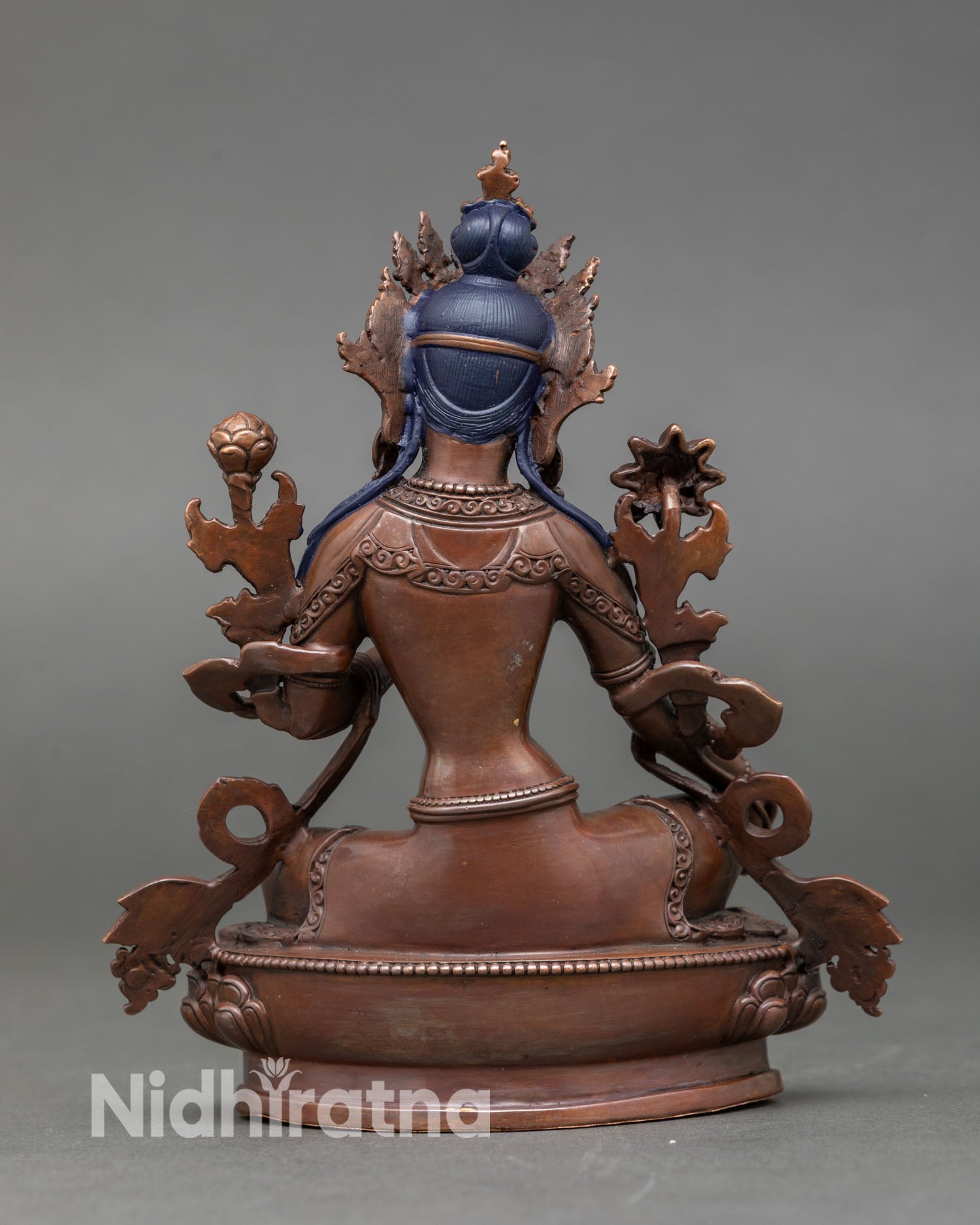 Back view of sacred Green Tara statue Newari craftsmanship oxidized copper finish Buddhist altar decor with lotus symbols and detailed Himalayan spiritual artistry