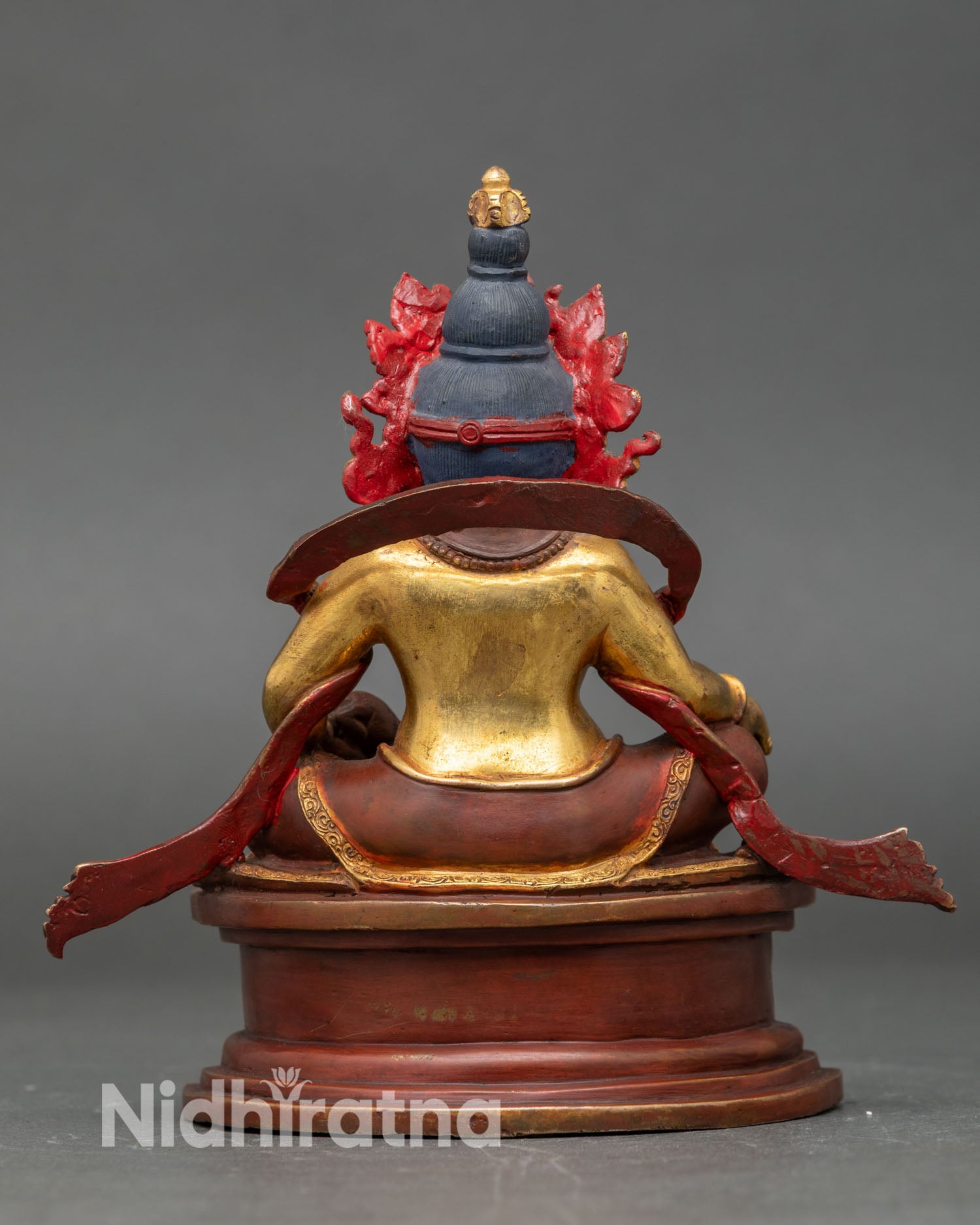Back view of handmade Dzambhala statue from Kathmandu Nepal copper sculpture gold gilded antique finish intricate carved garments sacred altar decor