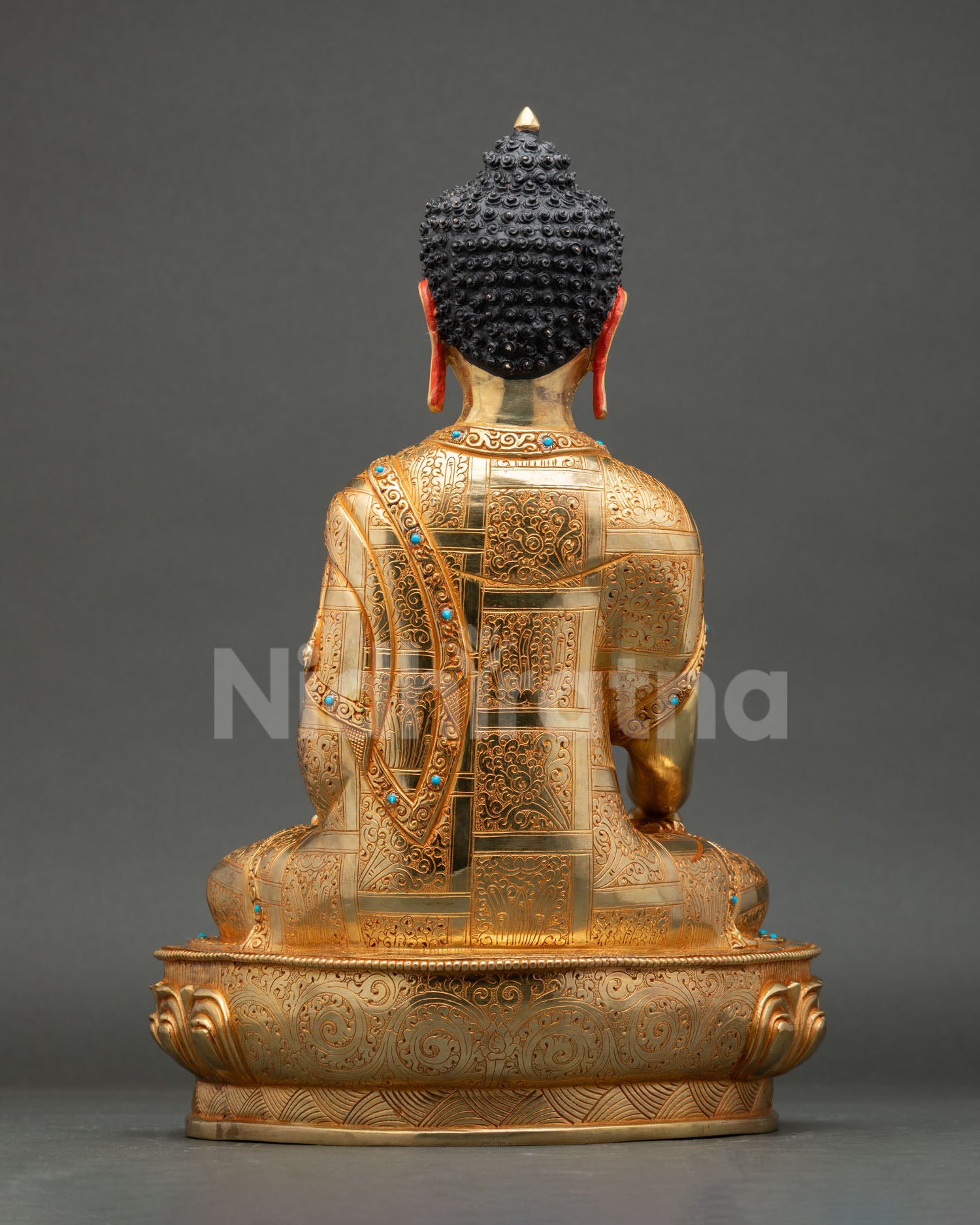 Back view of handmade Shakyamuni Buddha statue copper gold finish flowing monastic robe turquoise stone detail, Buddhist art sculpture