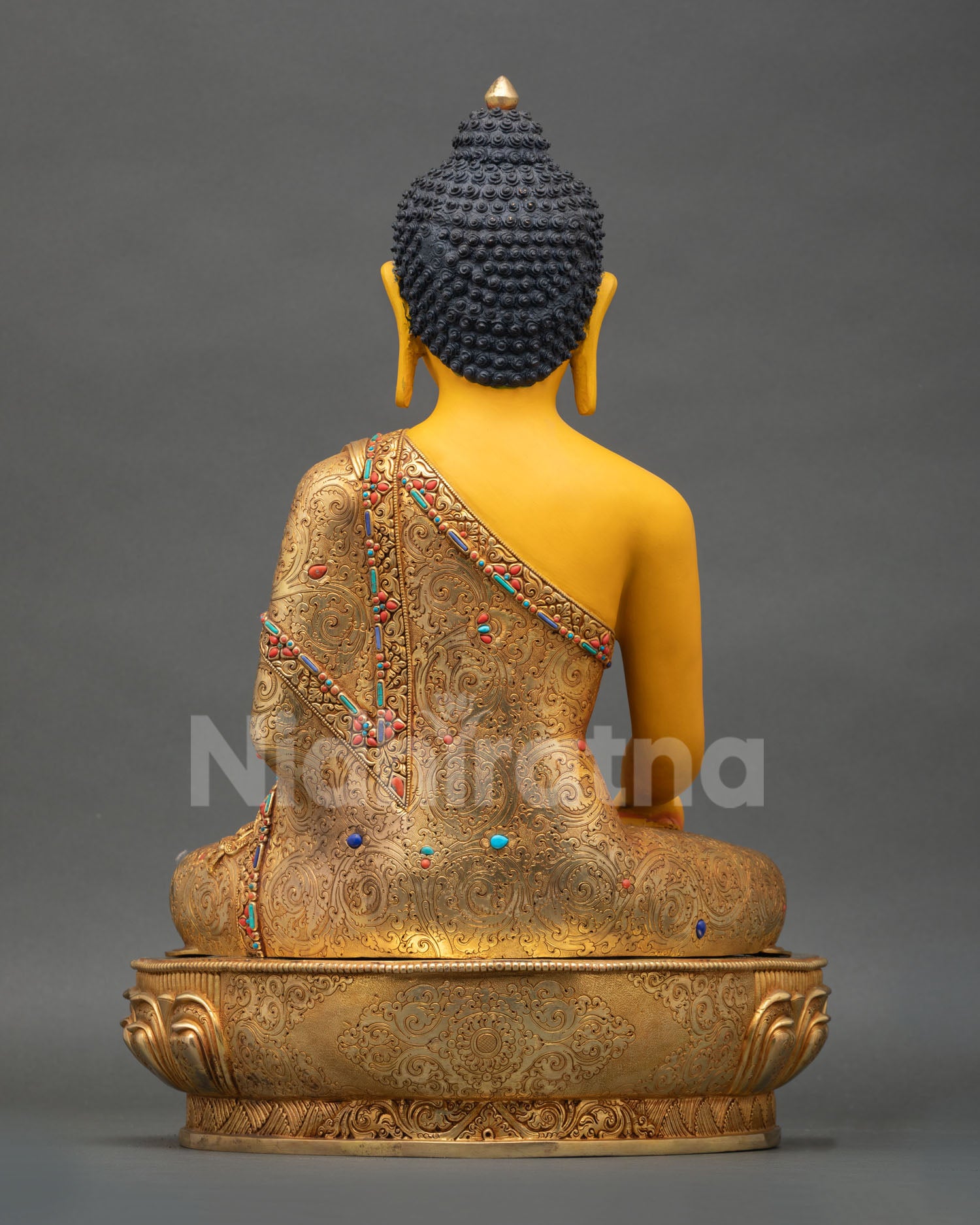Back view of Himalayan Buddha Shakyamuni statue with sacred mantra engravings gold gilded details and spiritual home decor presence