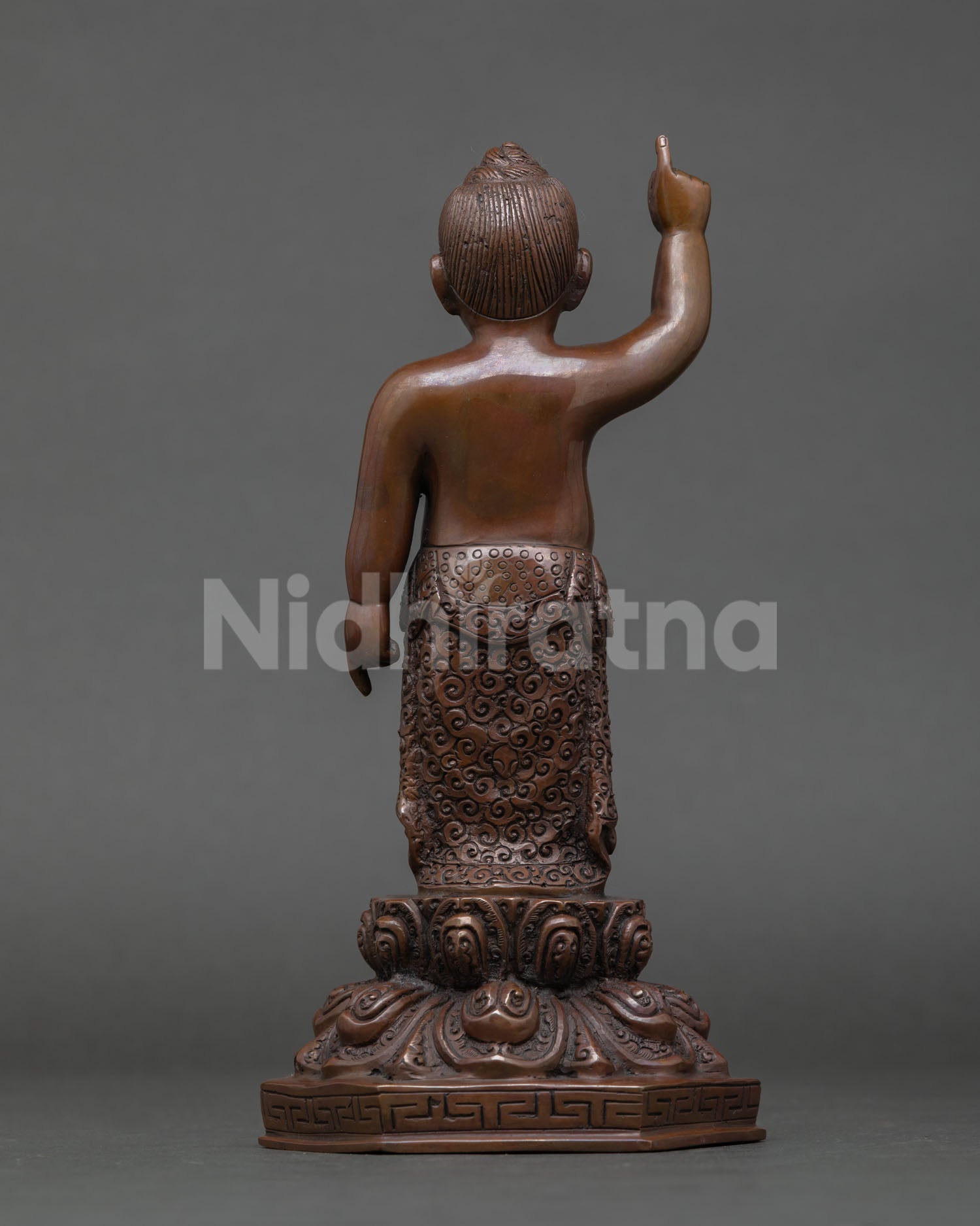 Back view of Little Buddha statue standing lotus throne base intricate detailing Nepal handmade sacred sculpture meditation room home altar