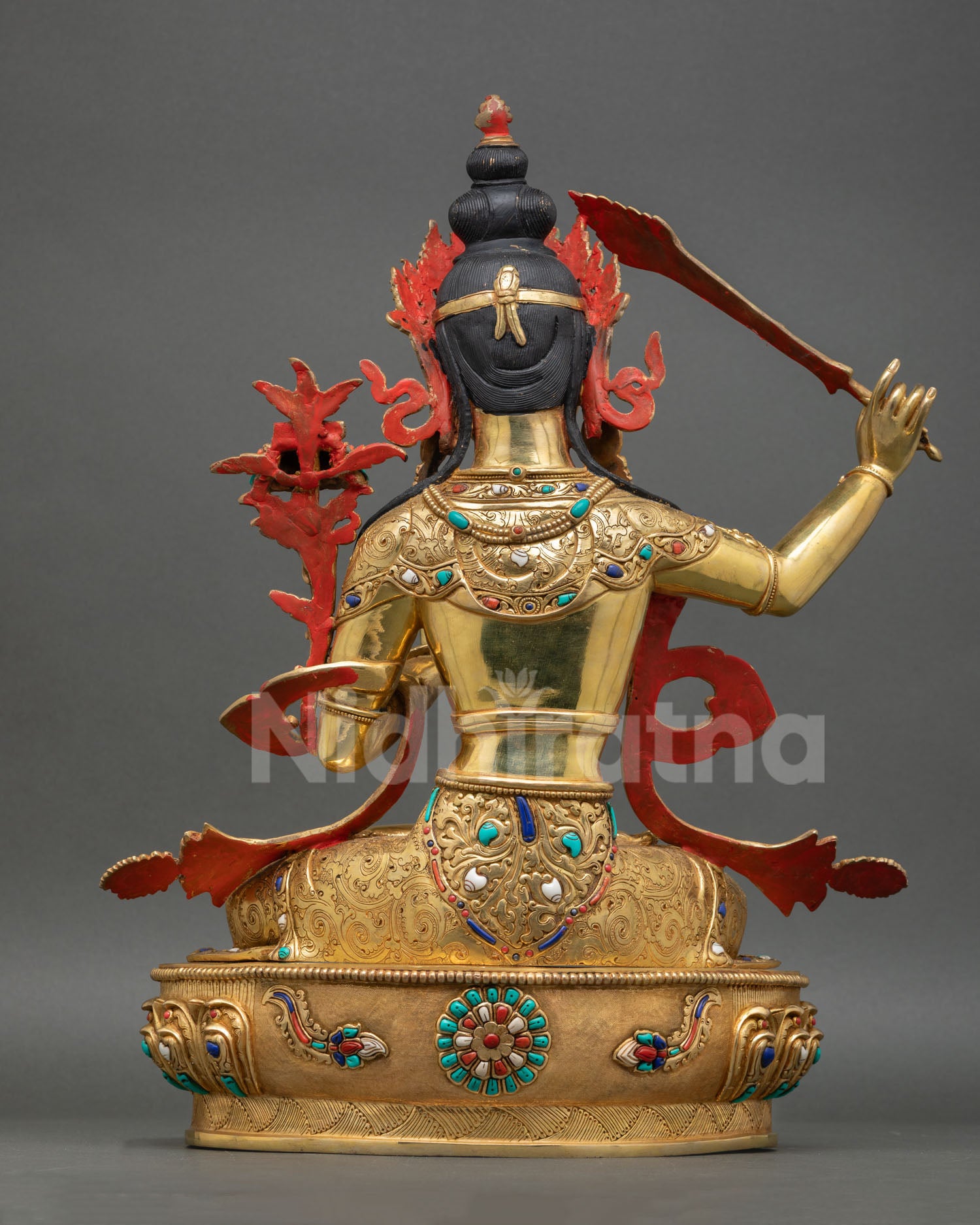 Back view of Nepalese Buddhist Manjushri statue with engraved robes and lotus pedestal