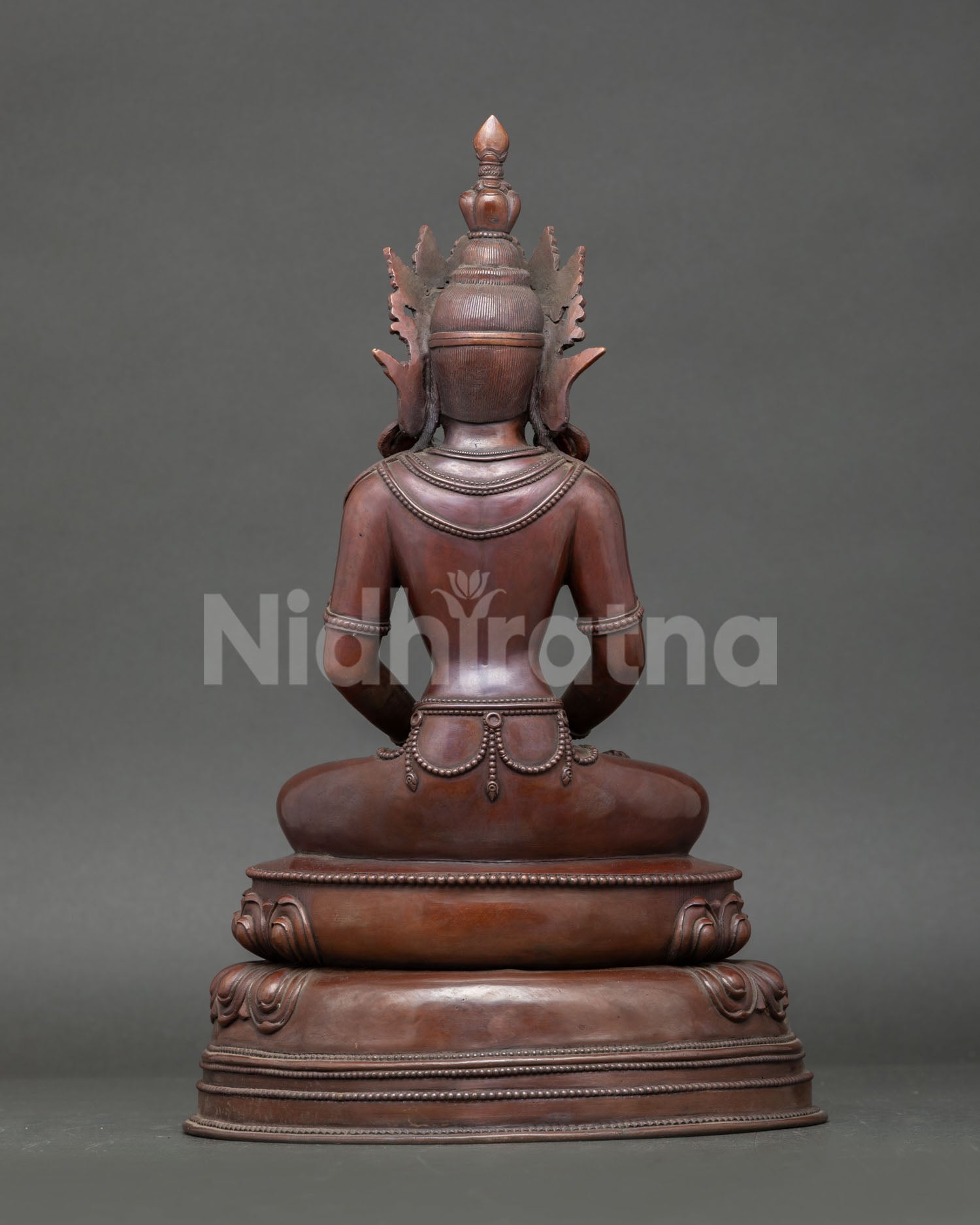 Back view of Amitayus statue showing detailed robes, lotus base, and oxidized copper finish