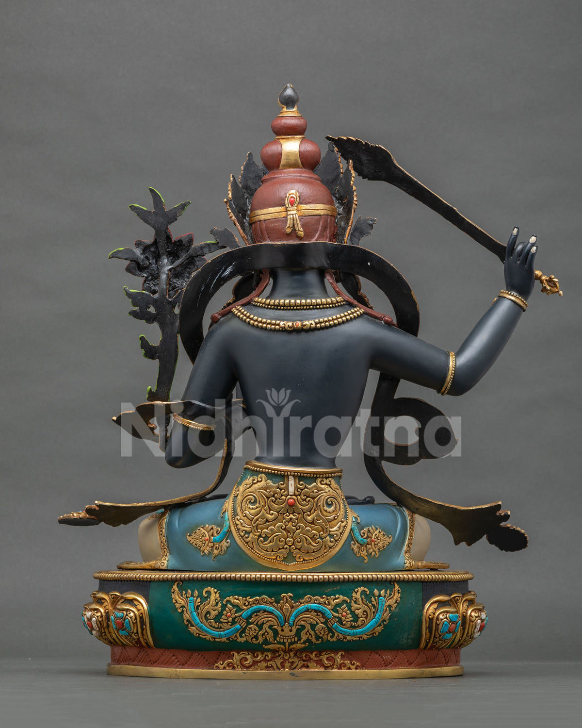 Back view of Black Manjushri statue showing hand-chased repoussé robe detail and gold gilded lotus base