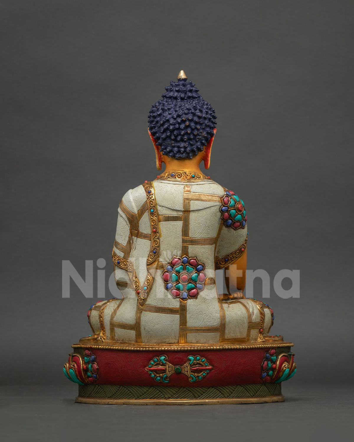 Back view of Buddha statue showing hand-carved robe detail and gold fire-gilded crown