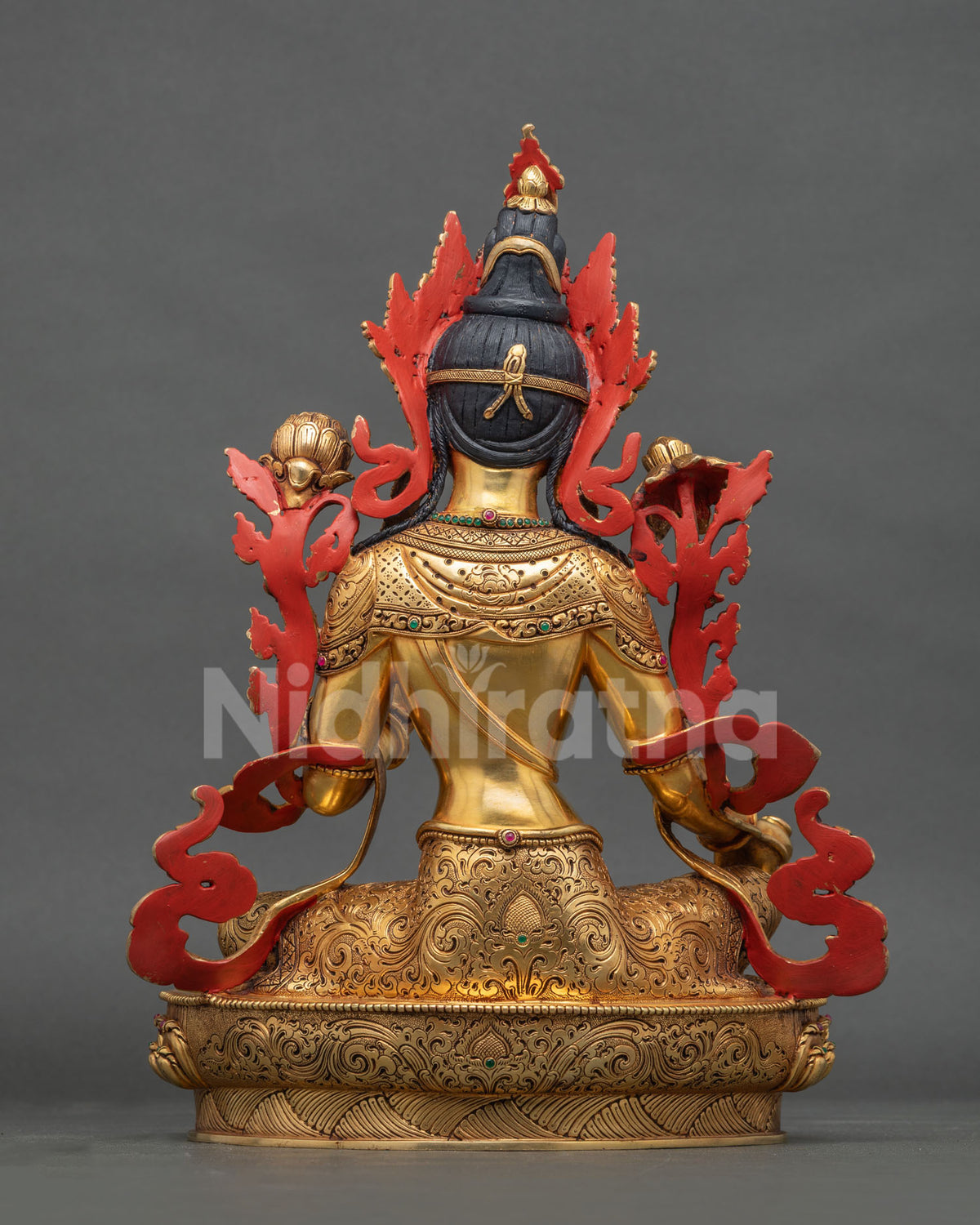Back view of copper Green Tara statue with hand-carved gold gilded robes and red painted accents