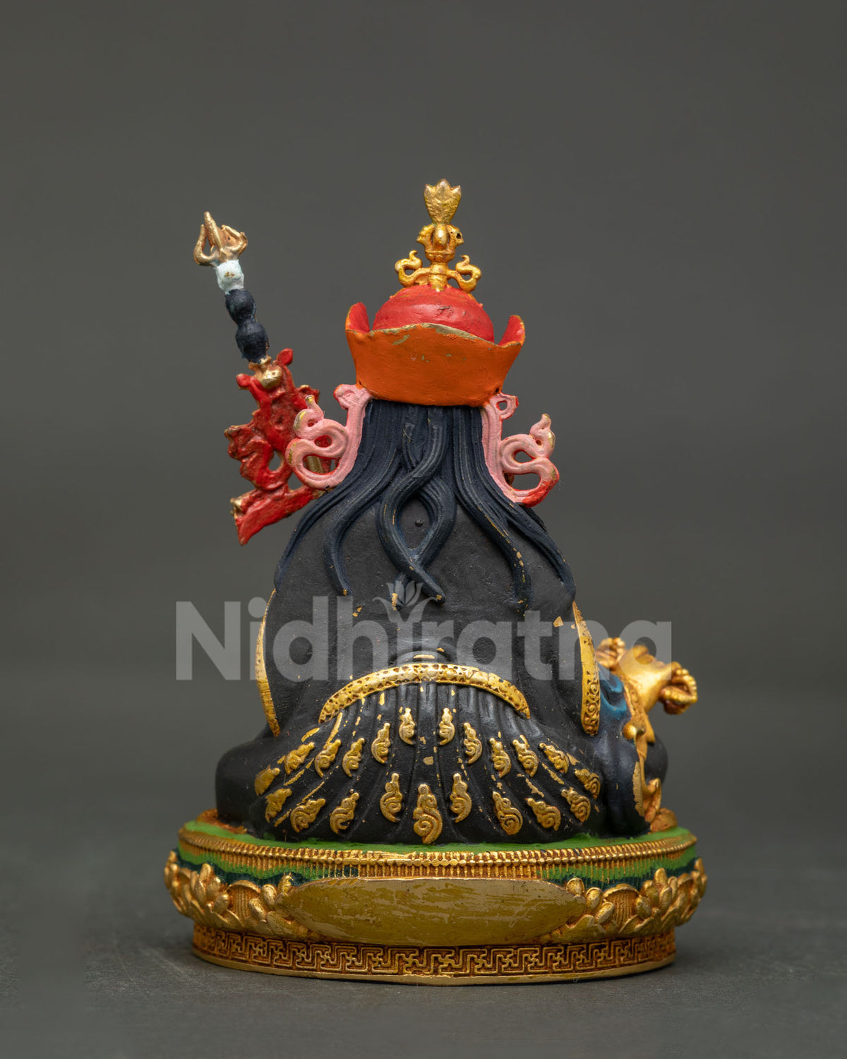 Back view of copper Guru Rinpoche statue showcasing detailed hair carving and gold-gilded trim.