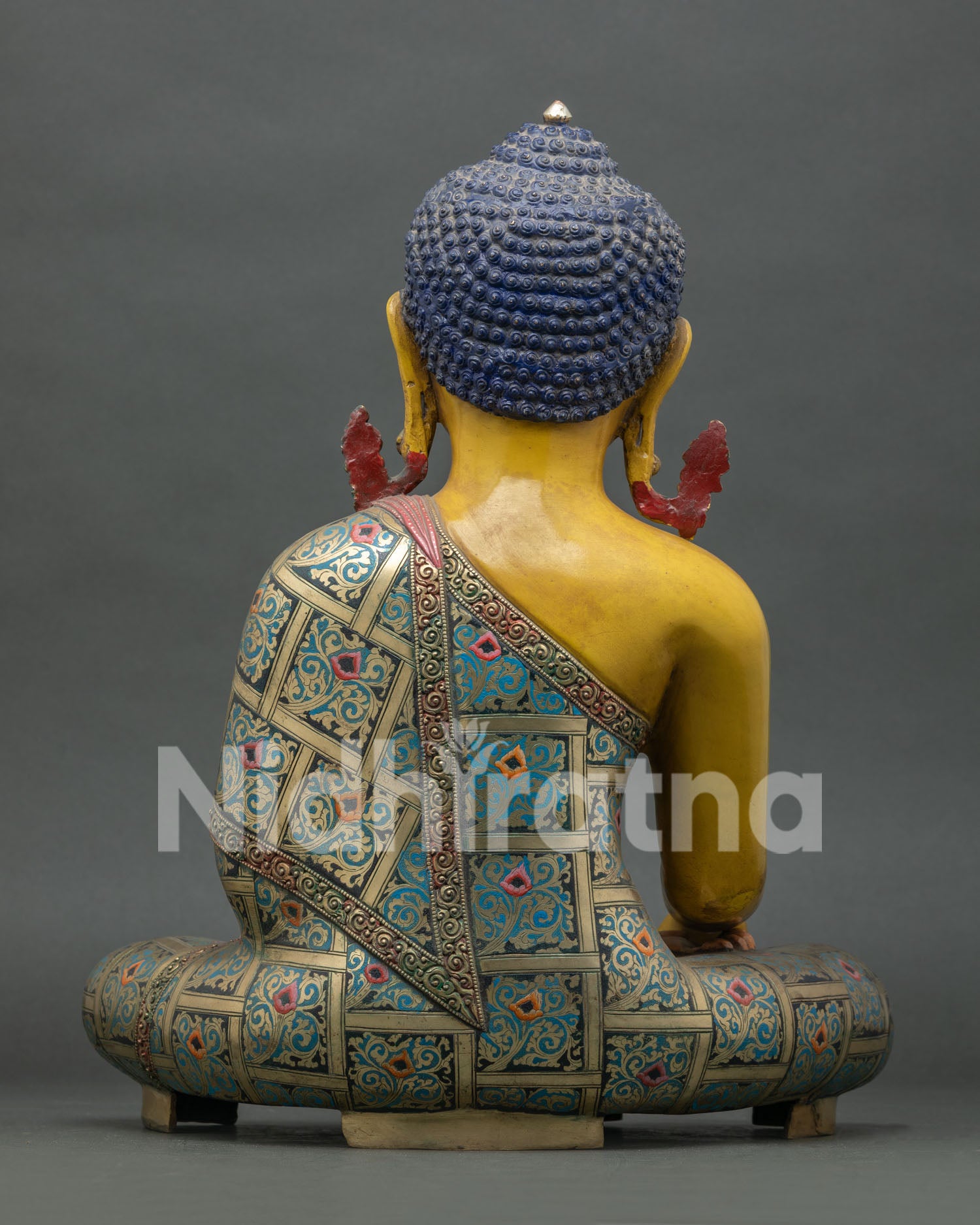 Back view of copper Shakyamuni Buddha statue showing detailed robe carvings and Himalayan artistry