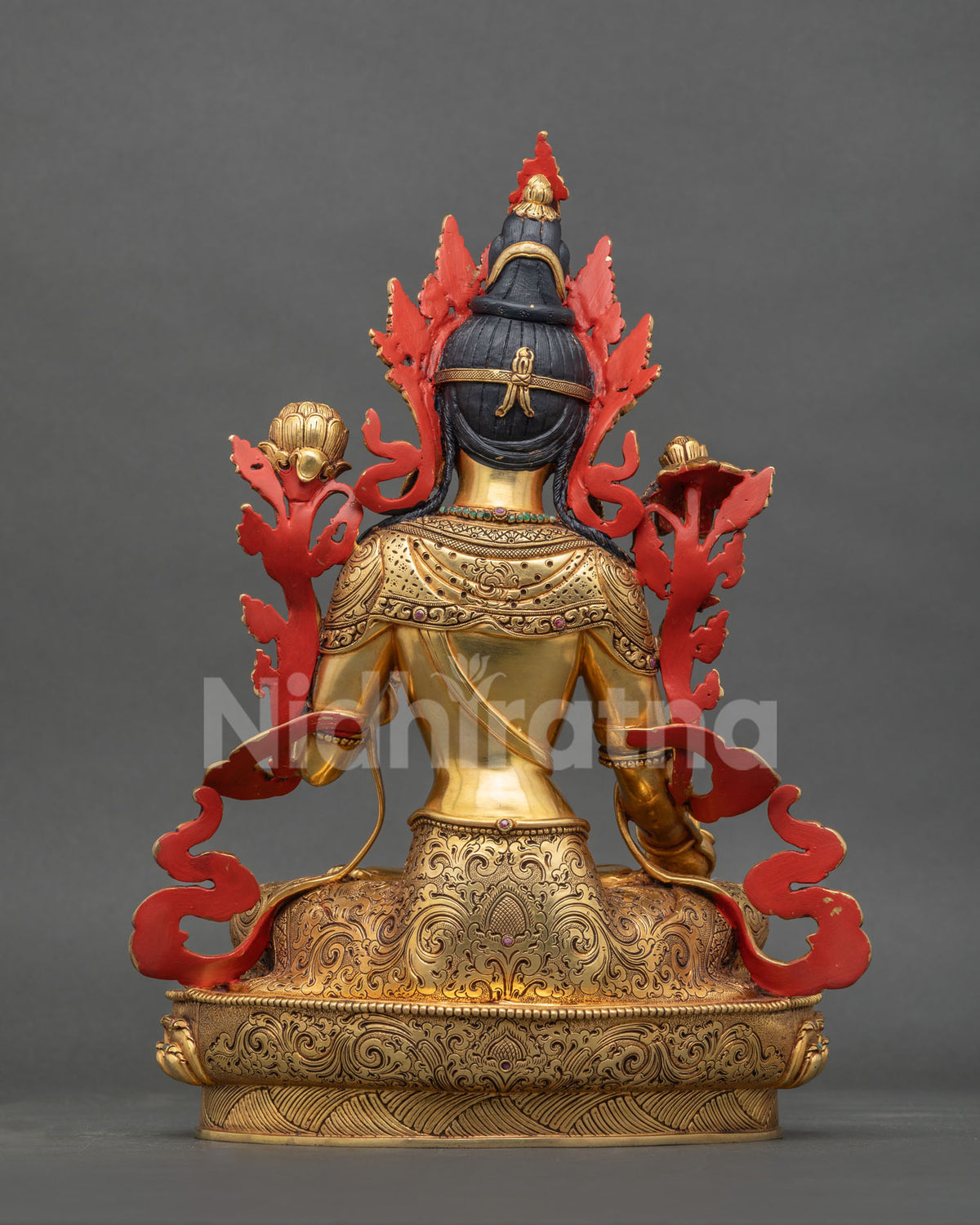 Back view of copper White Tara statue with hand-carved gold gilded robes and red painted accents