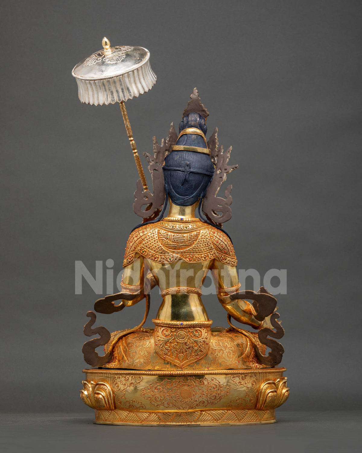 Back view of Dukar Statue with intricately engraved gold-gilded robe and silver parasol, Nepal