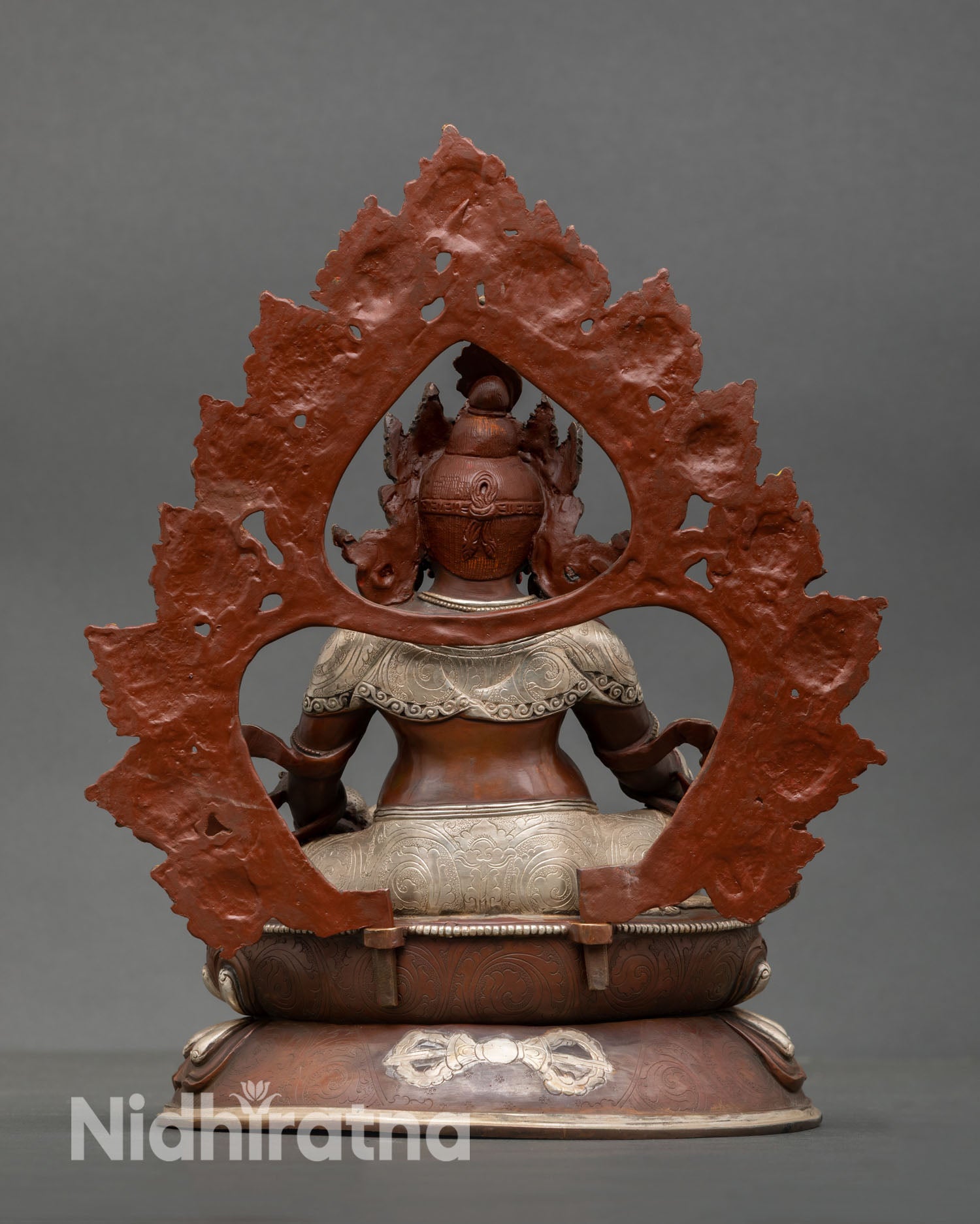 Back view of Dzambhala sculpture showing detailed craftsmanship and oxidized copper texture
