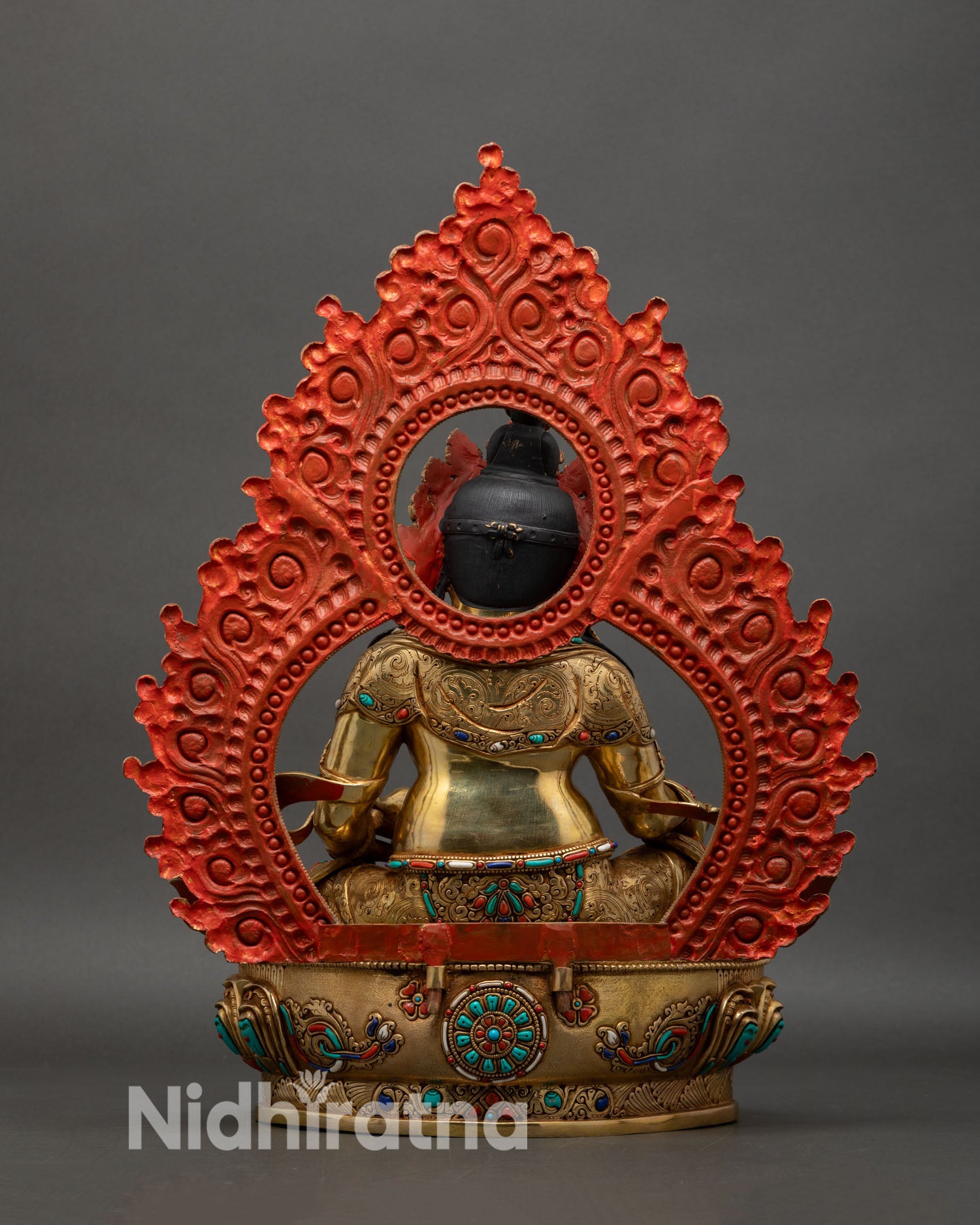 back view of dzambhala statue with engraved halo and detailed copper work