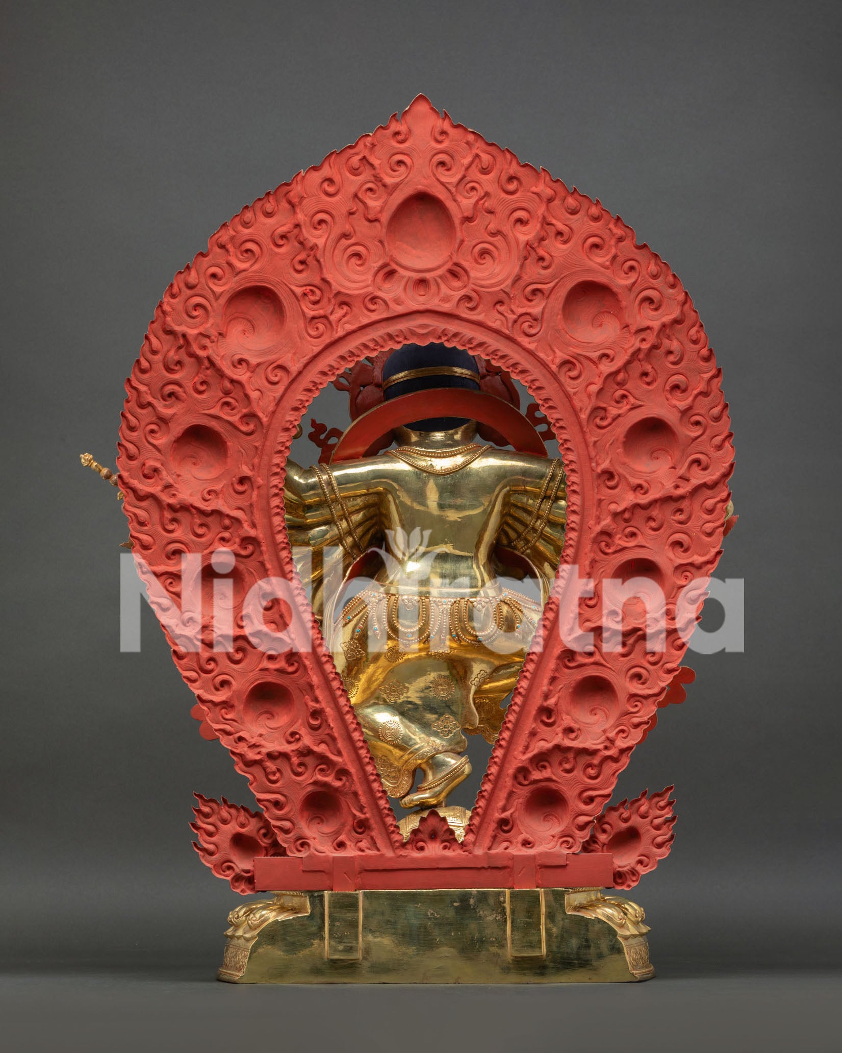 Back view of Ganesh statue showing red hand-carved flaming halo details