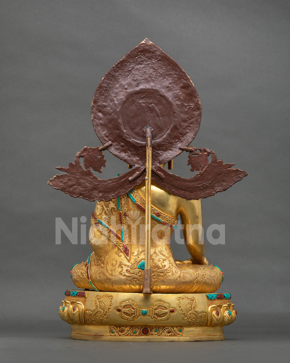 Back view of gilded copper Shakyamuni Buddha statue showing halo and rear detail