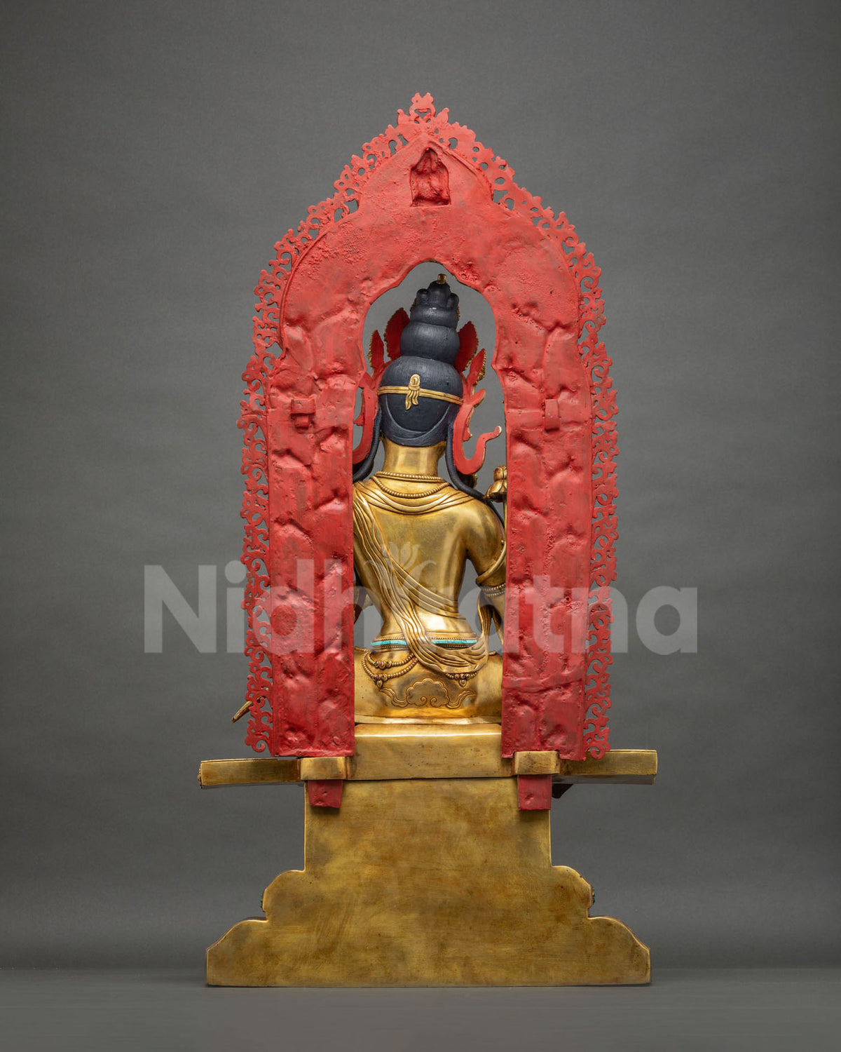 Back view of Green Tara statue showing red-painted halo and gold throne, handcrafted from copper