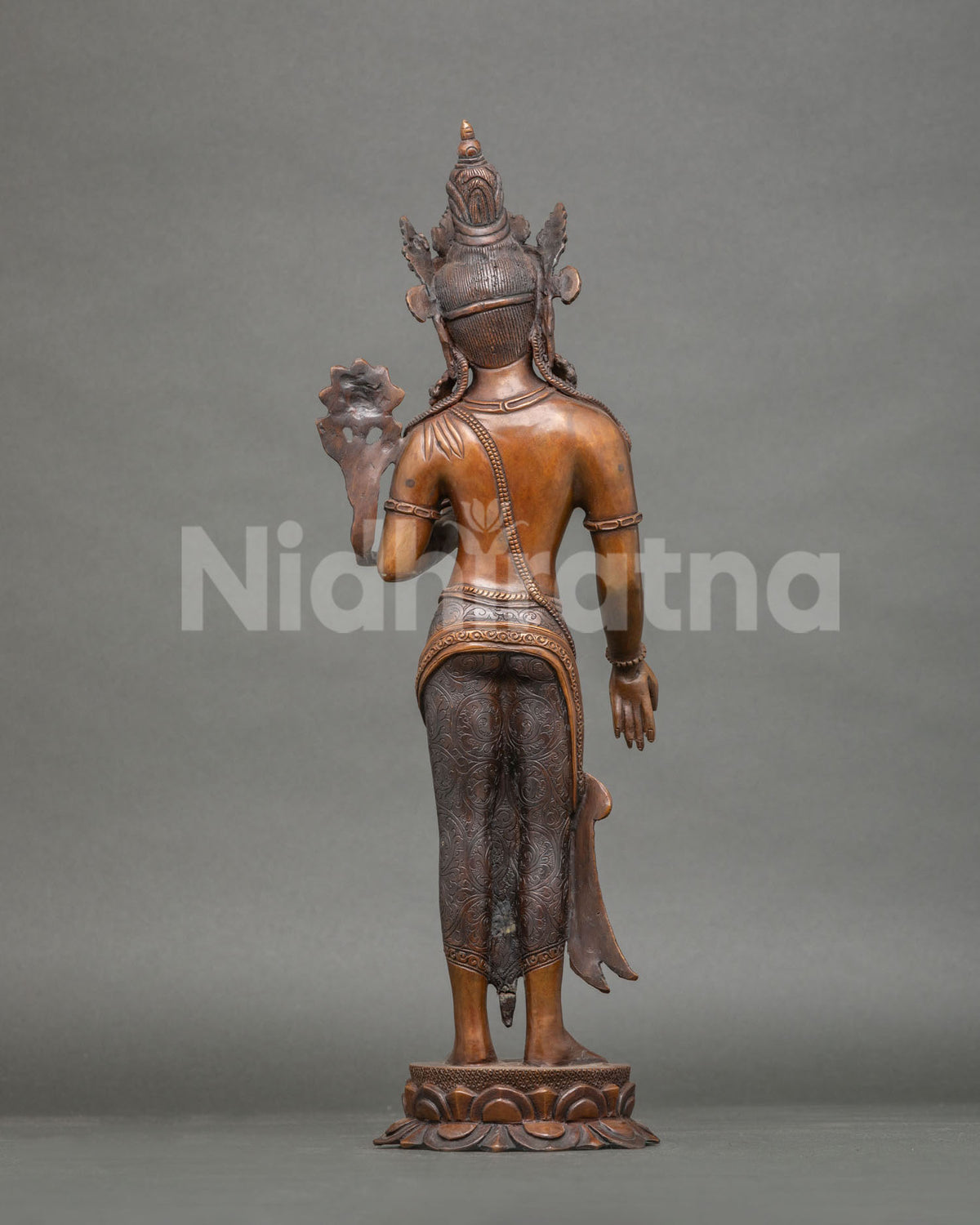Back view of handcrafted Avalokiteshvara statue showing engraved robe and lotus pedestal, Nepal