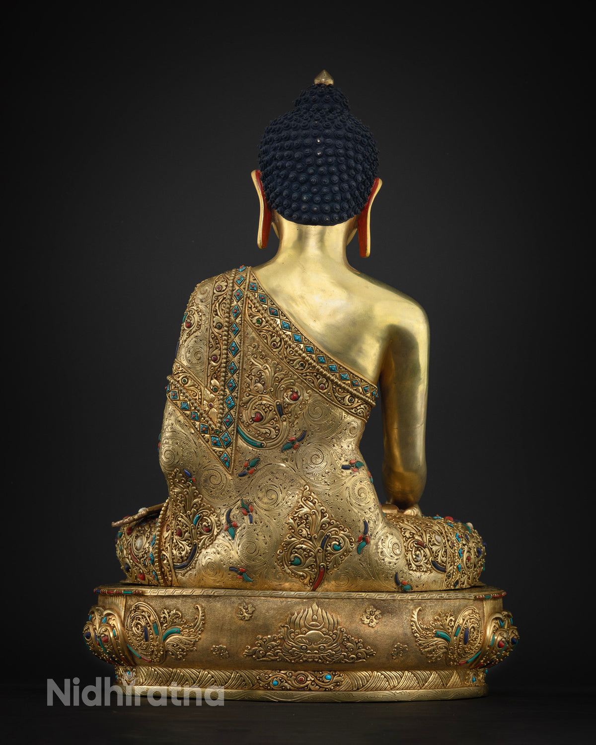 Back view of handcrafted copper Shakyamuni Buddha statue with ornate robe design
