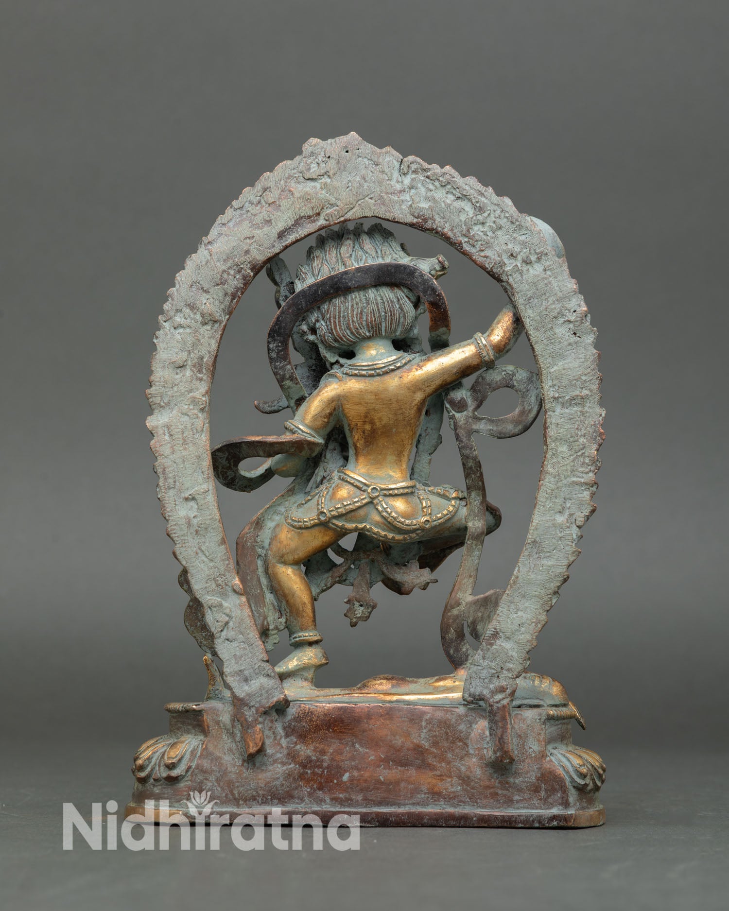 Back view of handcrafted Dorje Phagmo statue from Nepal showing antique patina detailed metal craftsmanship and flaming halo design